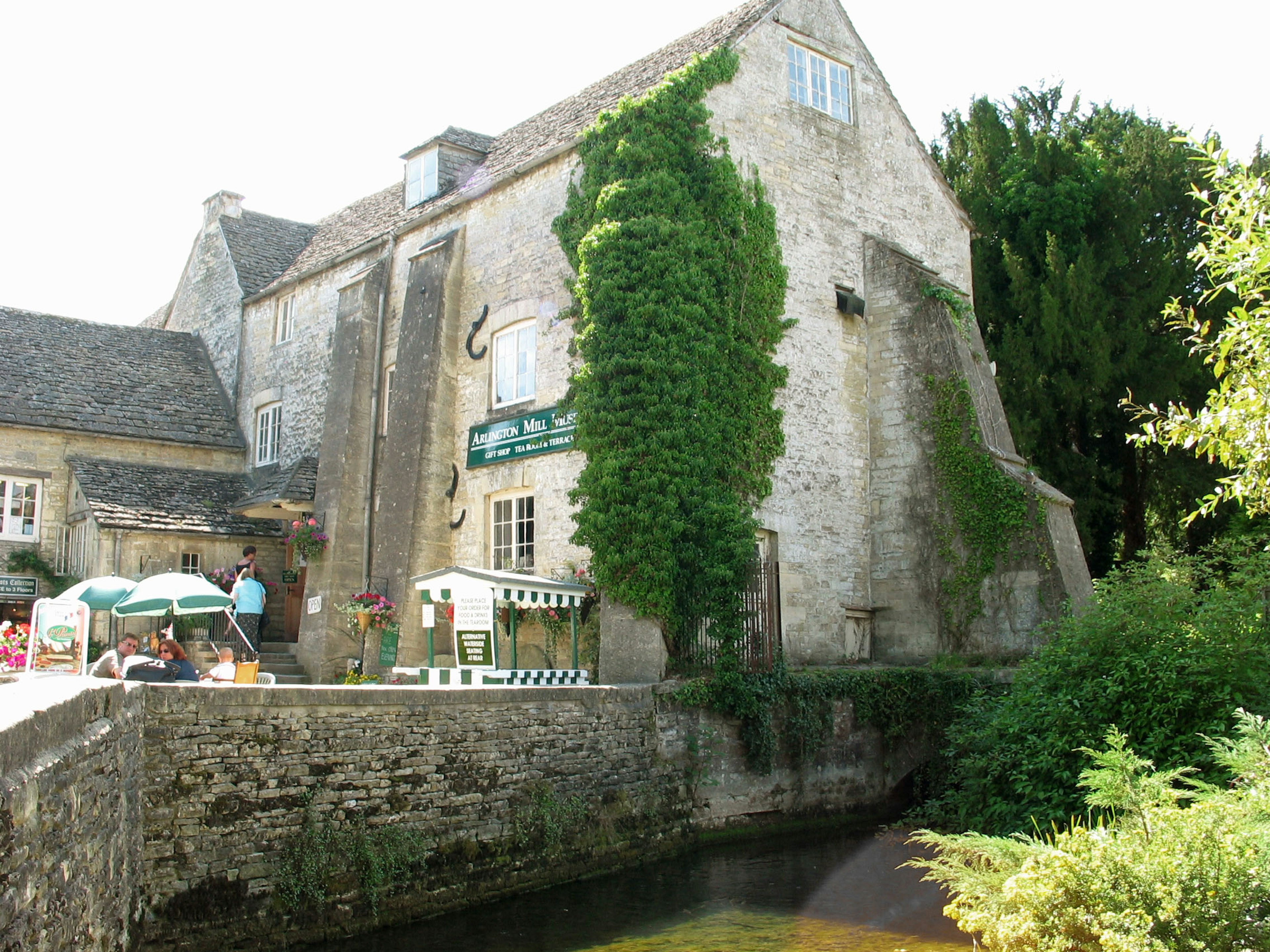 Bâtiment en pierre avec verdure le long d'un cours d'eau