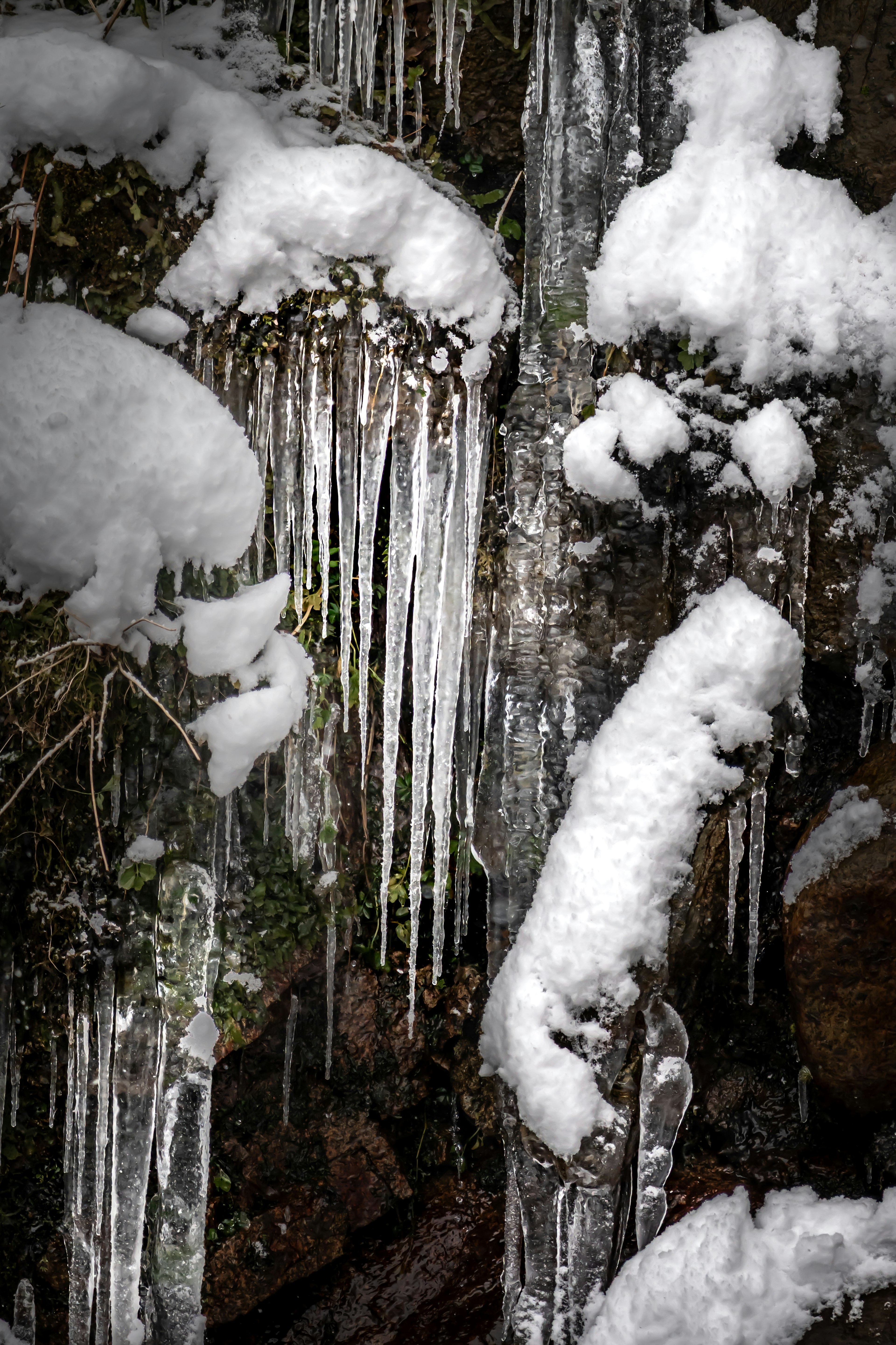 Primer plano de carámbanos y rocas cubiertas de nieve