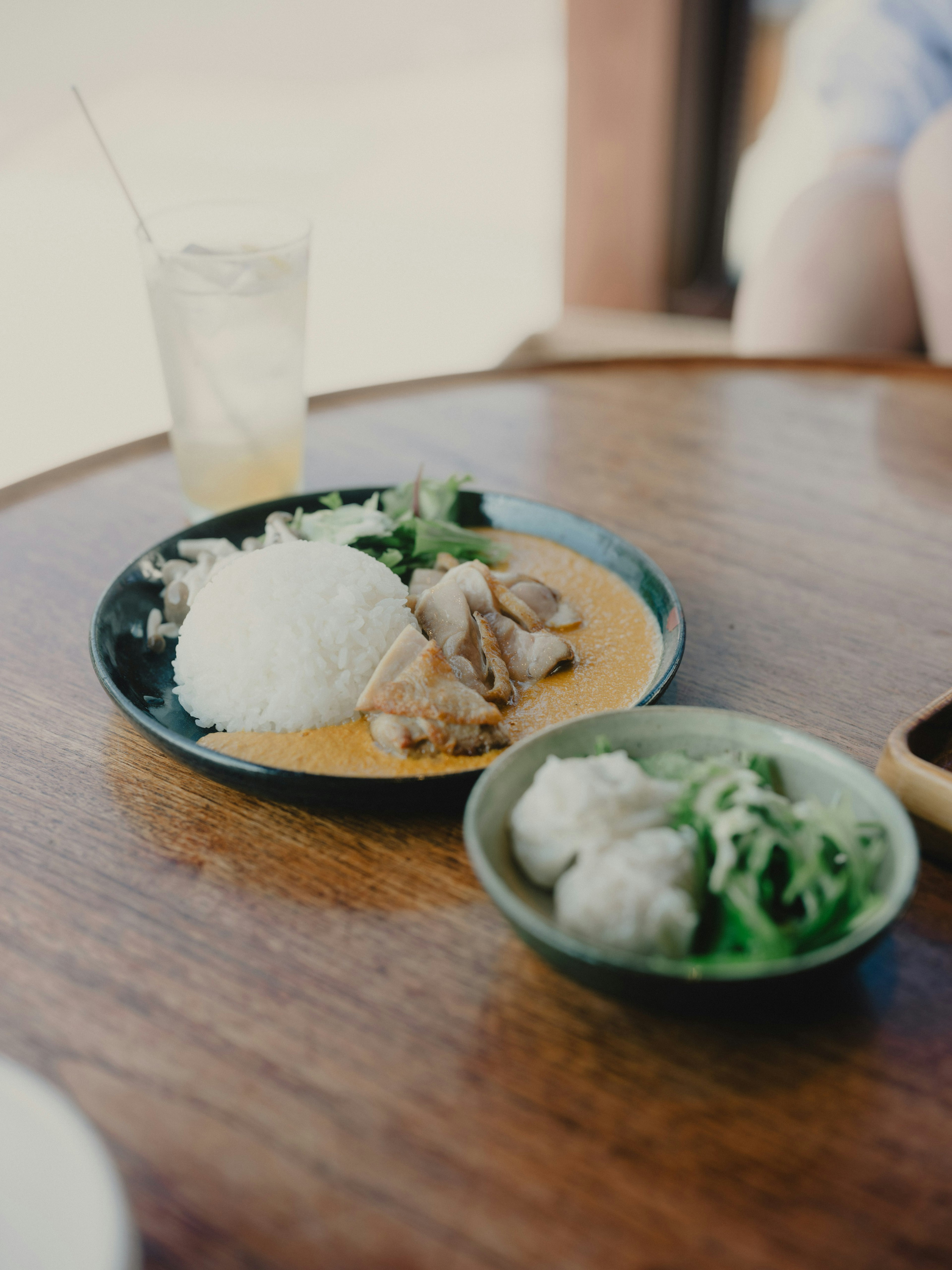 Piring makanan dengan nasi dan daging di atas meja kayu