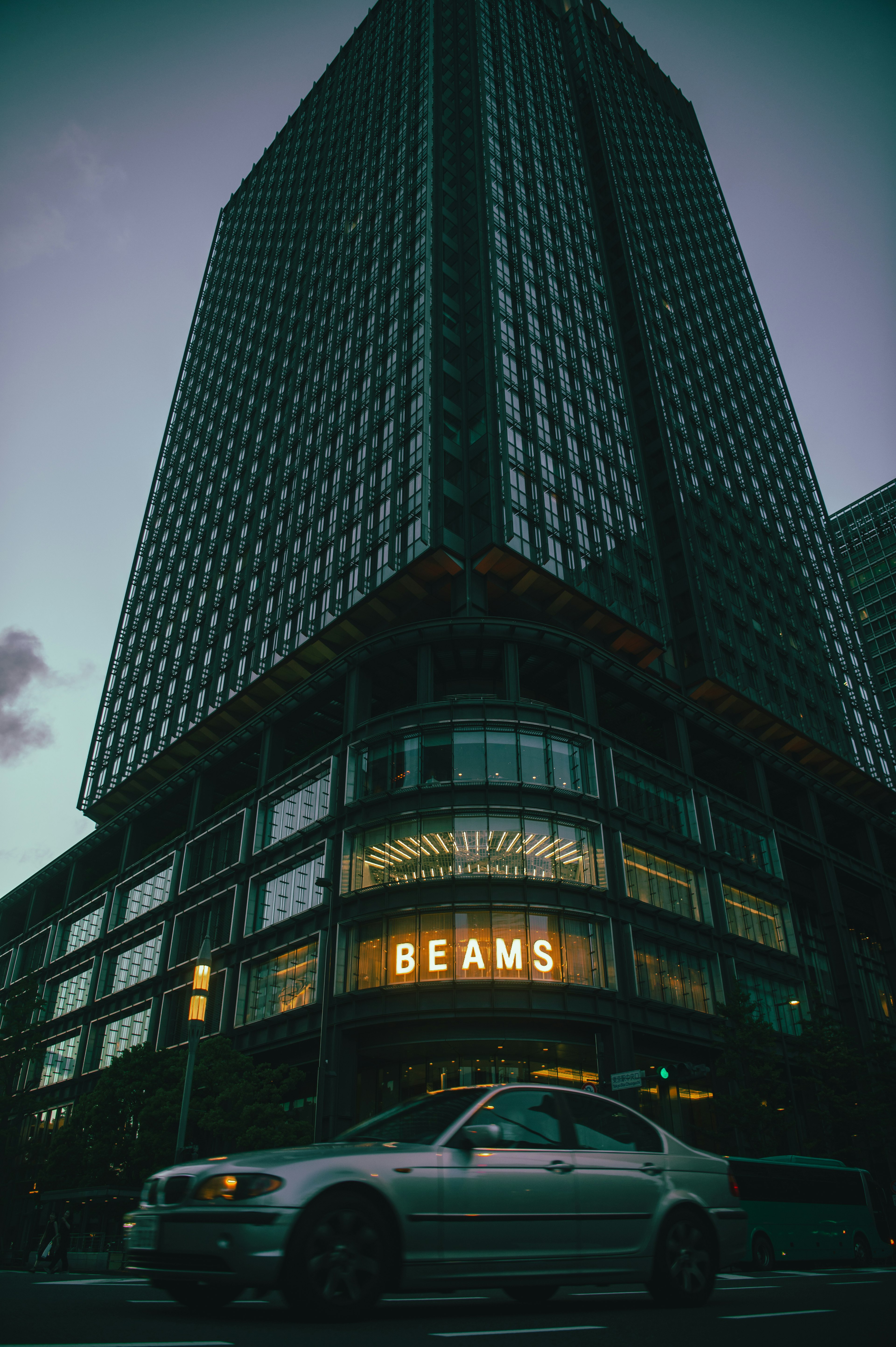 Modern building with a prominent BEAMS sign and a car in front