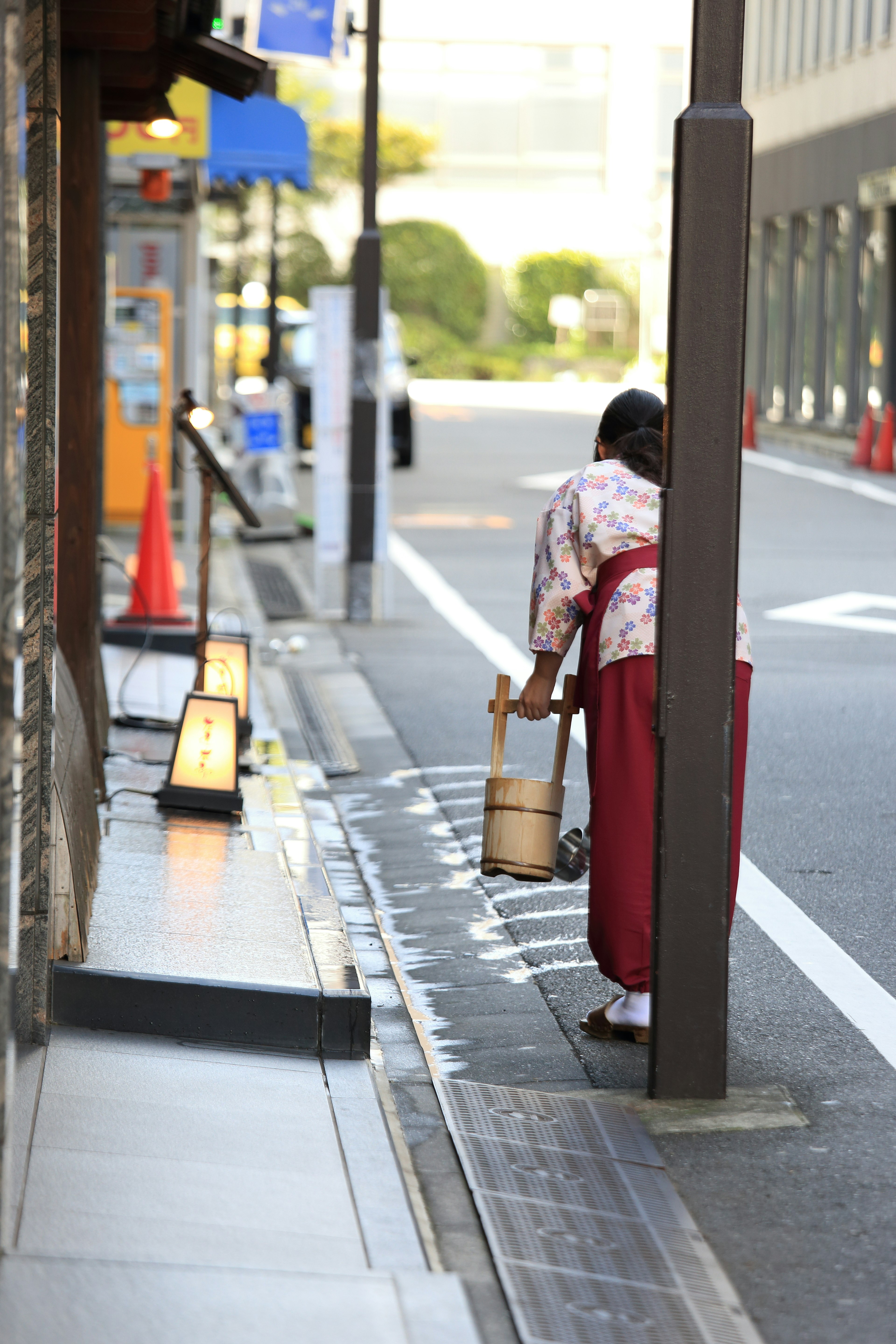 Eine Frau in einem traditionellen Kimono, die die Straße entlanggeht