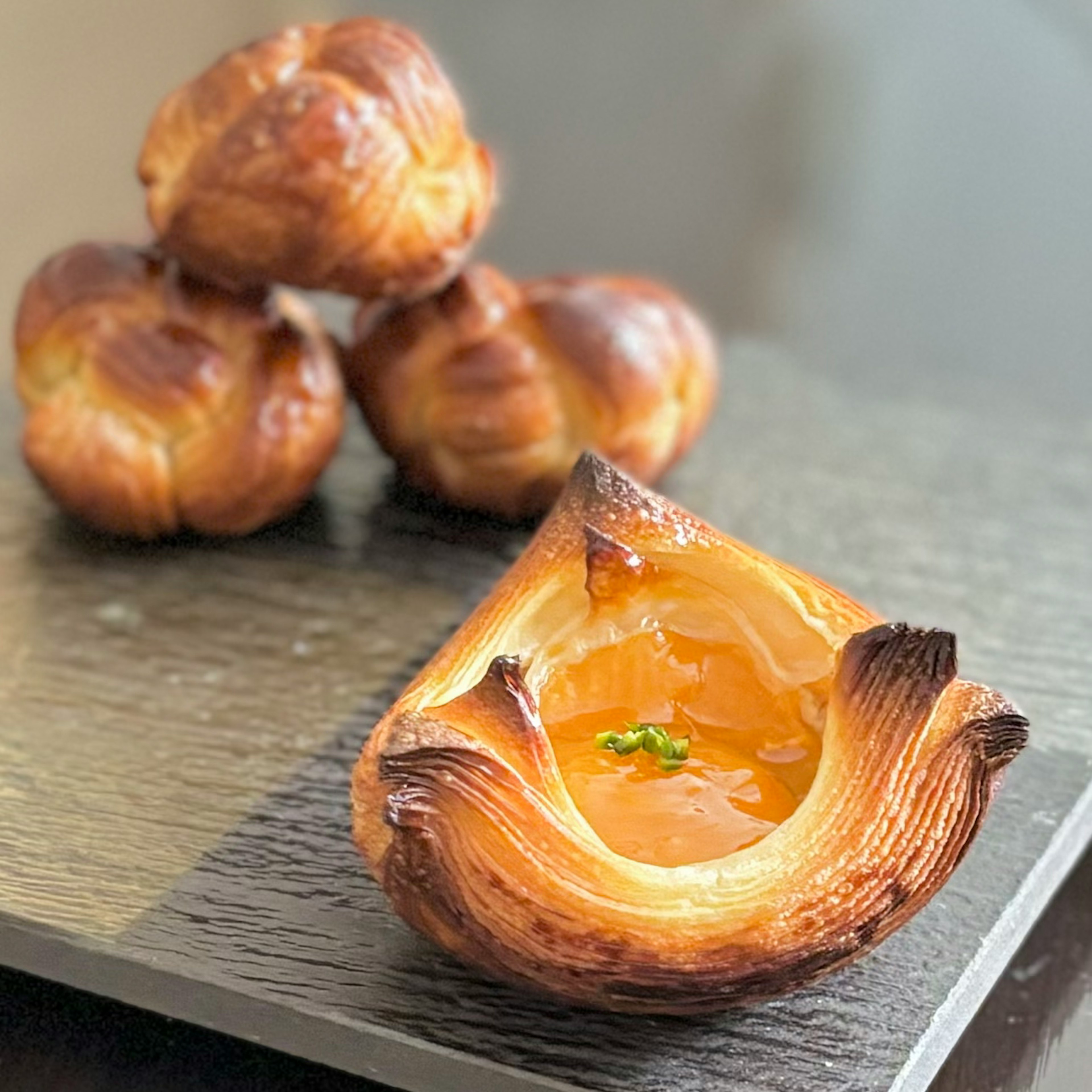 A freshly baked pastry on a plate with an orange filling visible inside