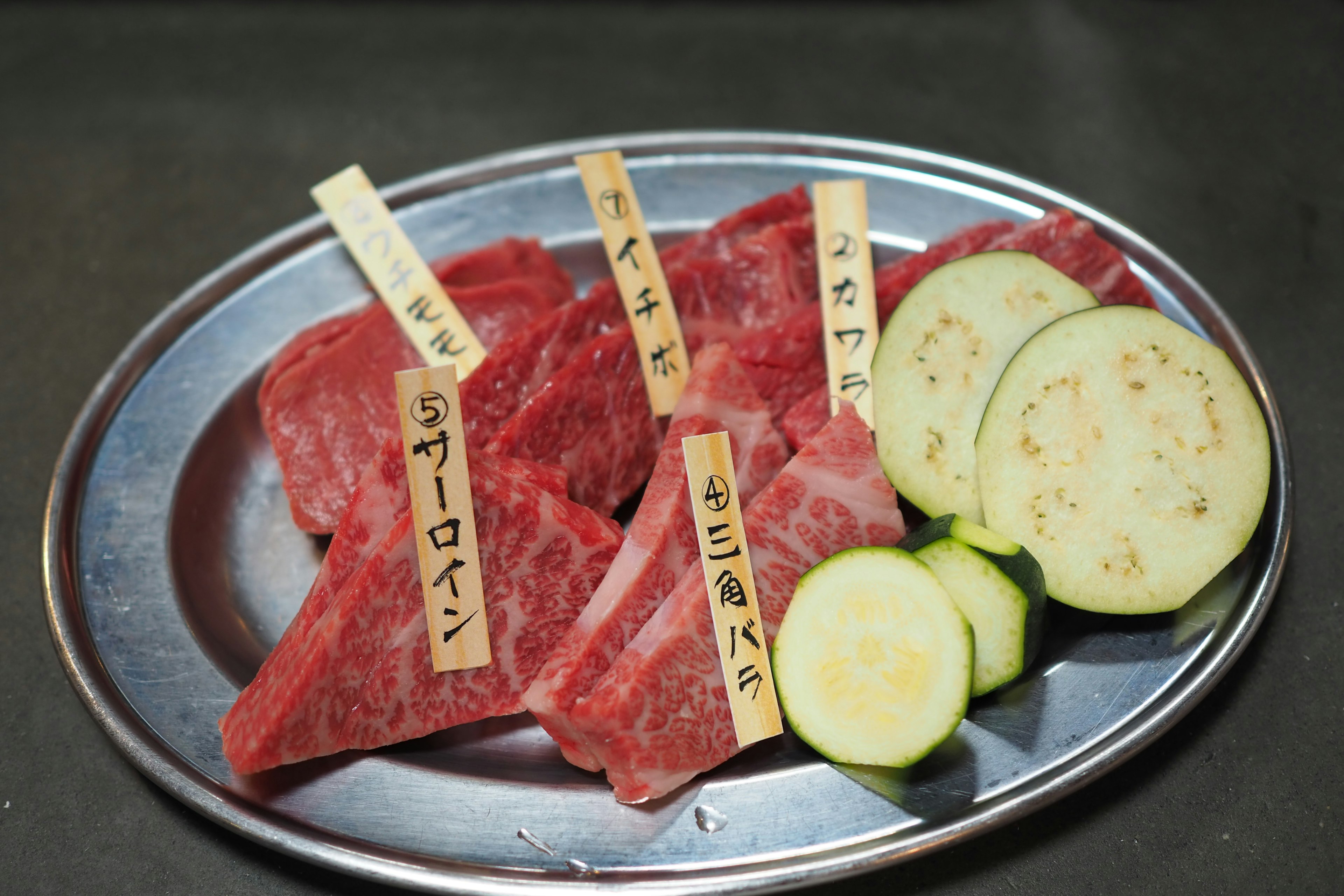 Variedad de cortes de carne y verduras en rodajas en un plato