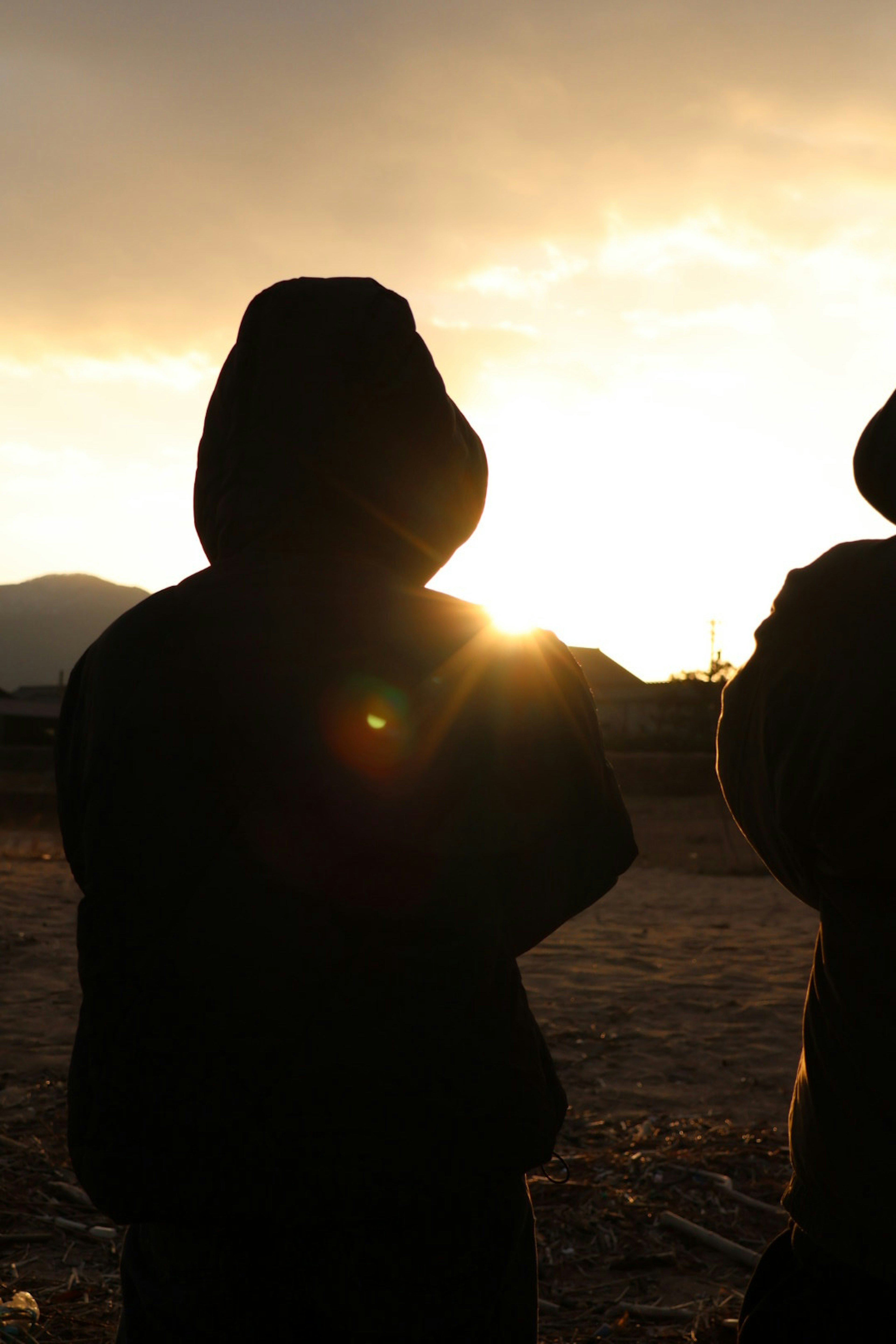 Silhouettes of two people against a sunset