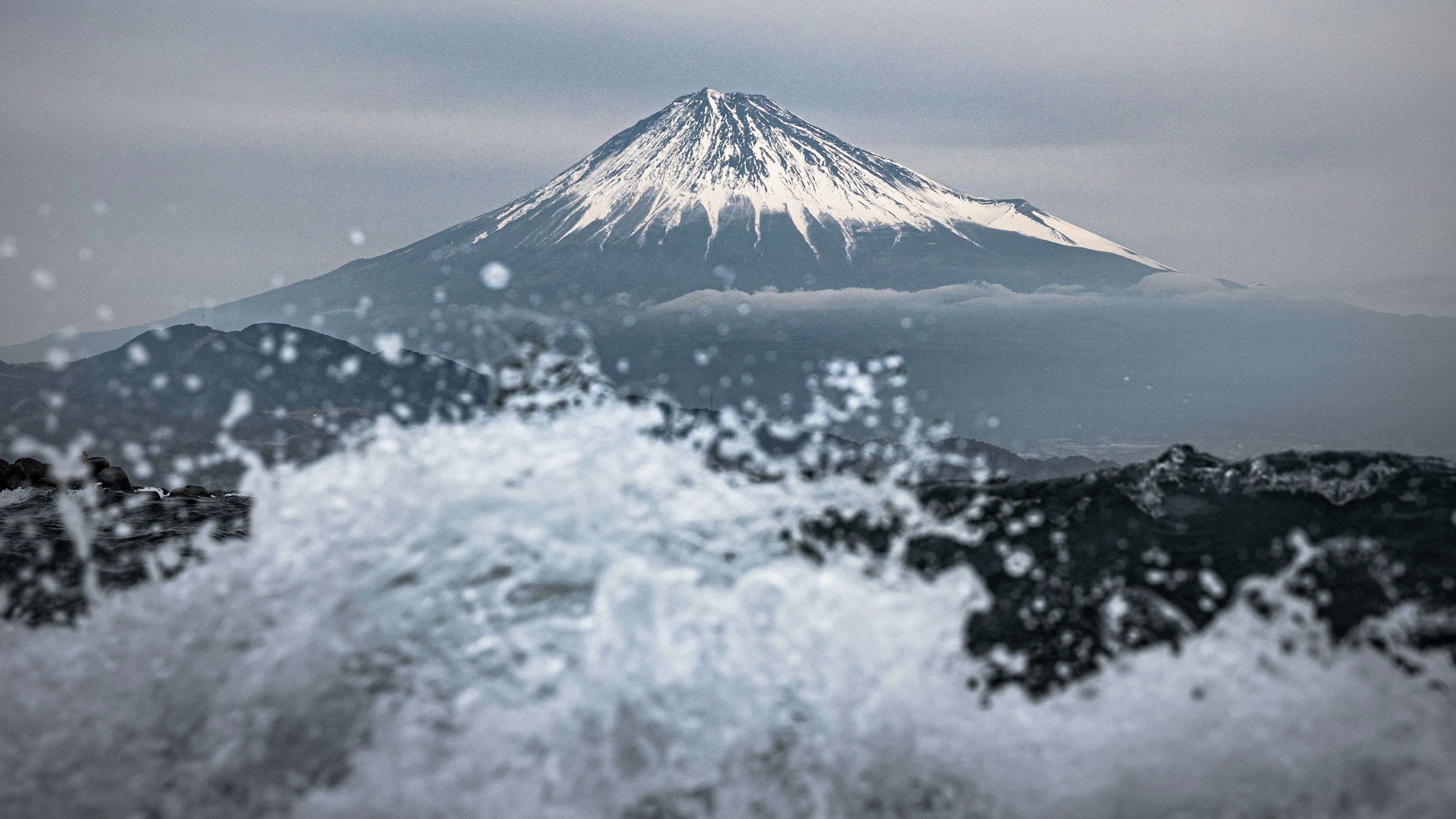 Monte Fuji elevándose detrás de olas rompientes