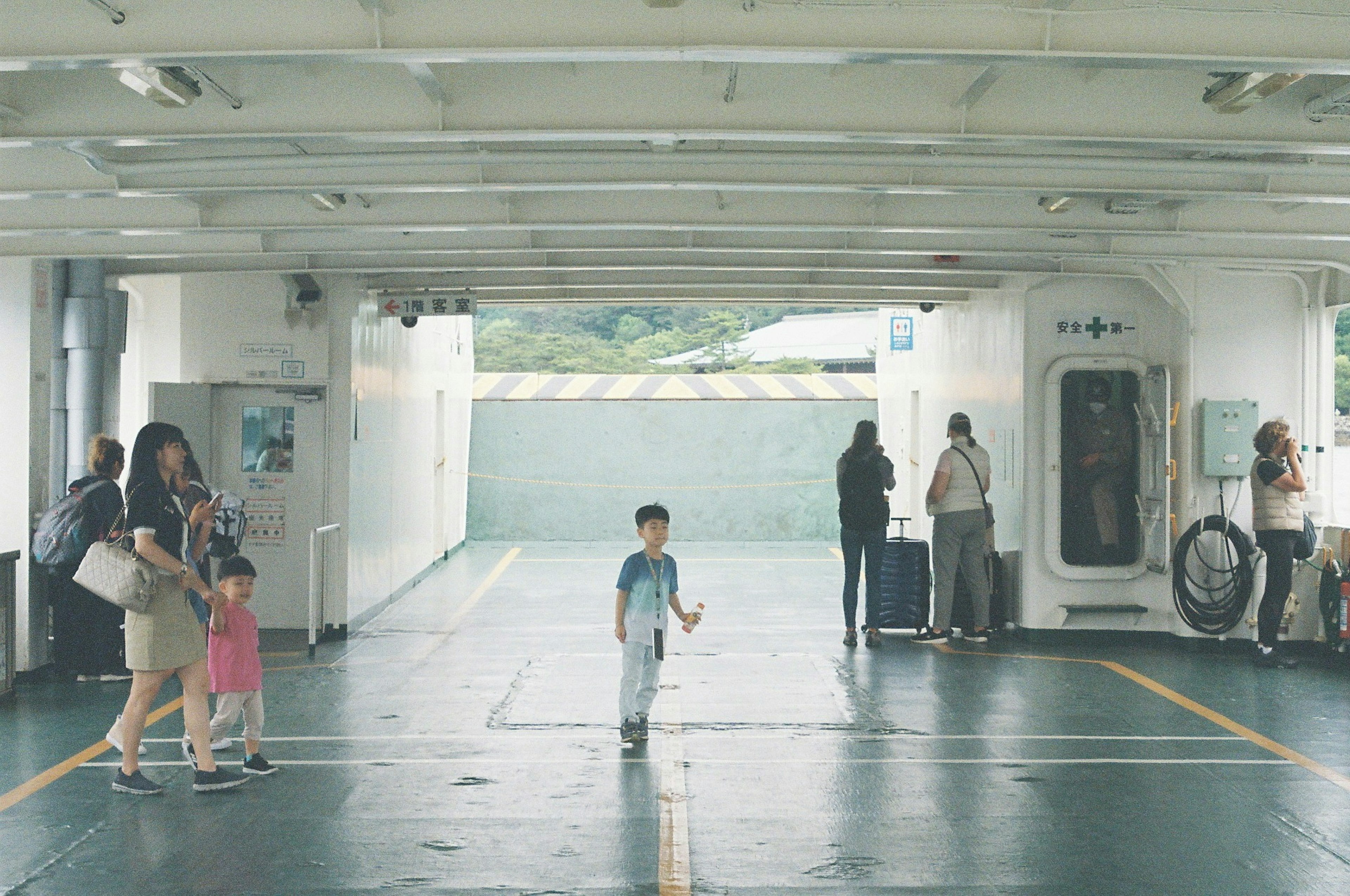 フェリーの内部で遊ぶ子供と大人たちの風景