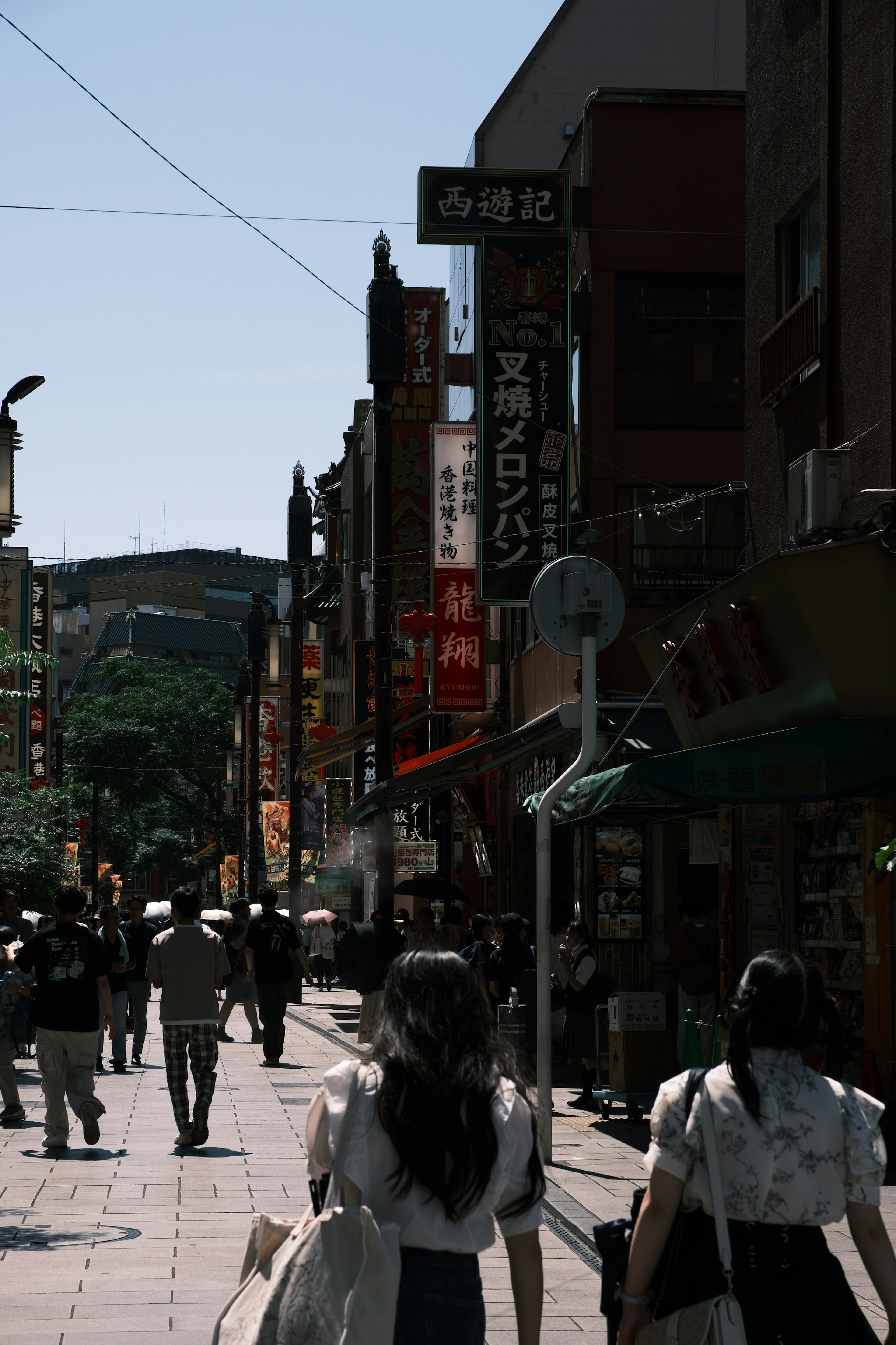 Busy street scene with people walking and various signs