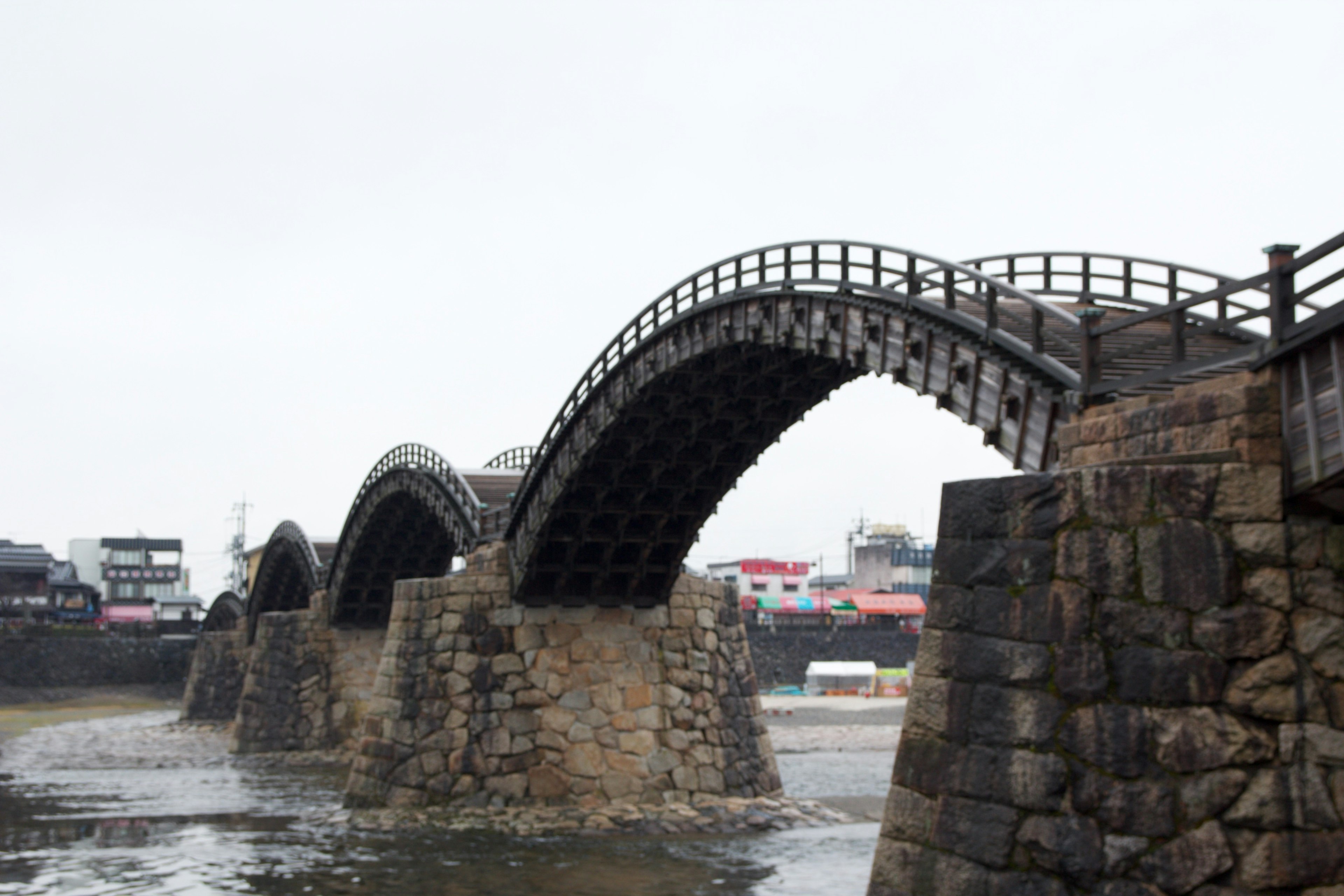 Steinbrücke mit einem sichtbaren Bogen über einer ruhigen Wasseroberfläche