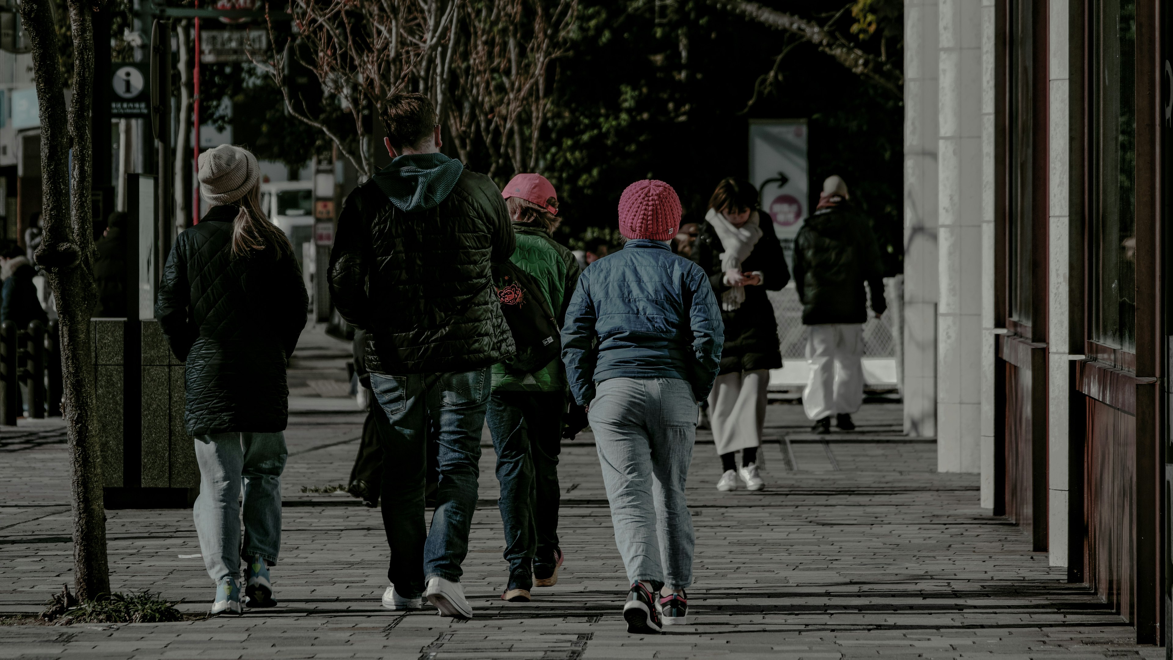 Gruppe junger Leute, die die Straße entlang gehen, mit bunten Frisuren und lässiger Kleidung