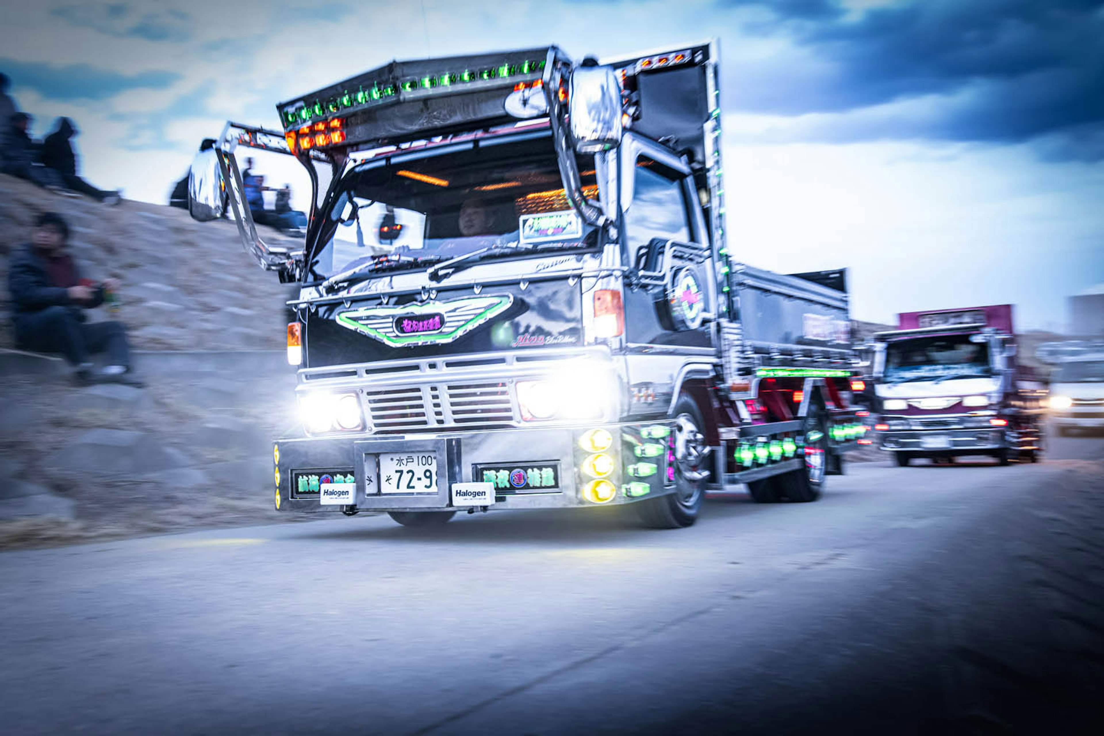 Colorfully decorated truck driving on a road at dusk