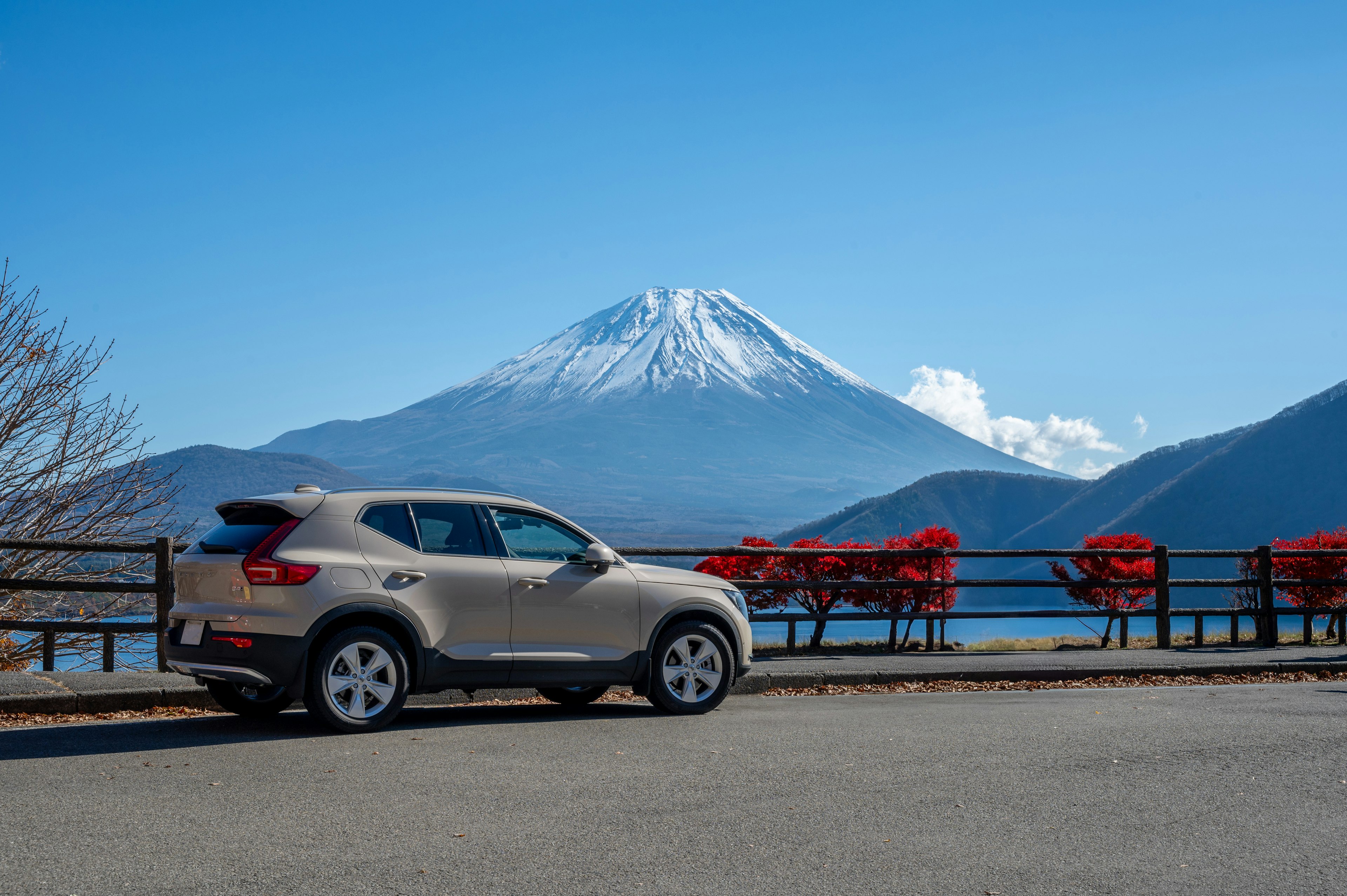 富士山を背景にしたシルバーのSUVと赤いベンチ