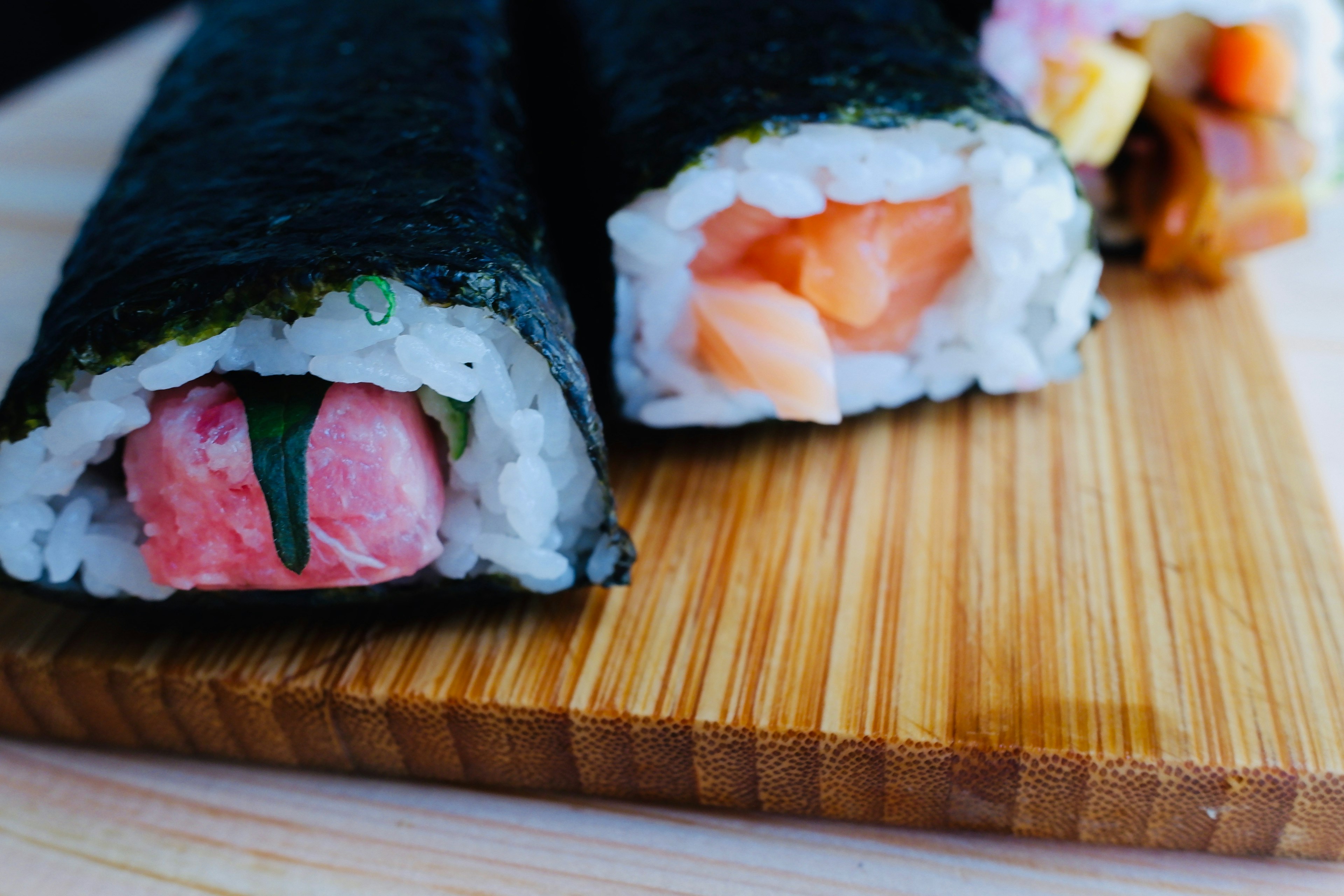 Rouleaux de sushi frais exposés sur une planche en bois