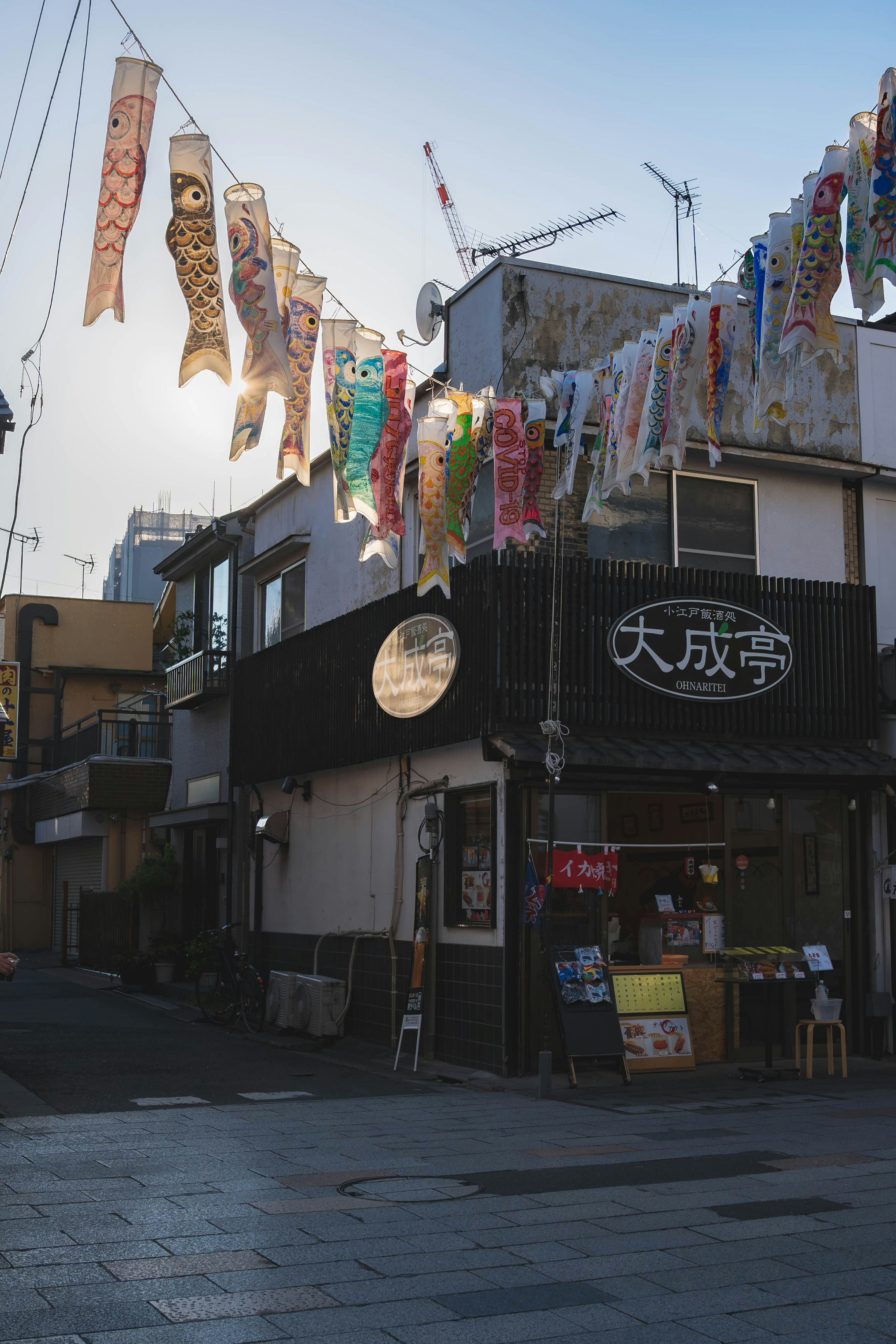 日本の街並みにある小さな店舗とカラフルなのぼり旗