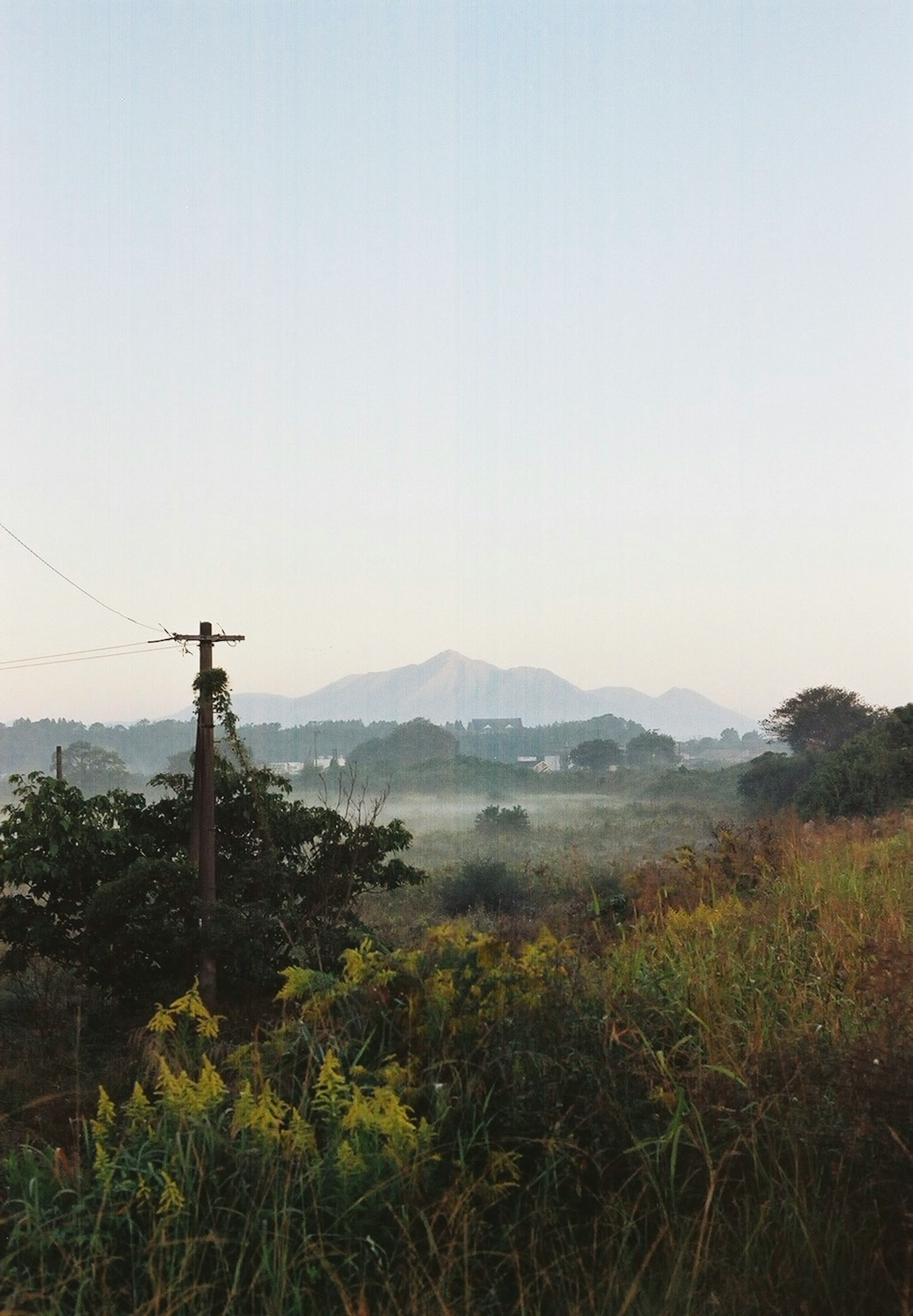 Ruhige Landschaft mit entfernten Bergen und grasbewachsenen Feldern