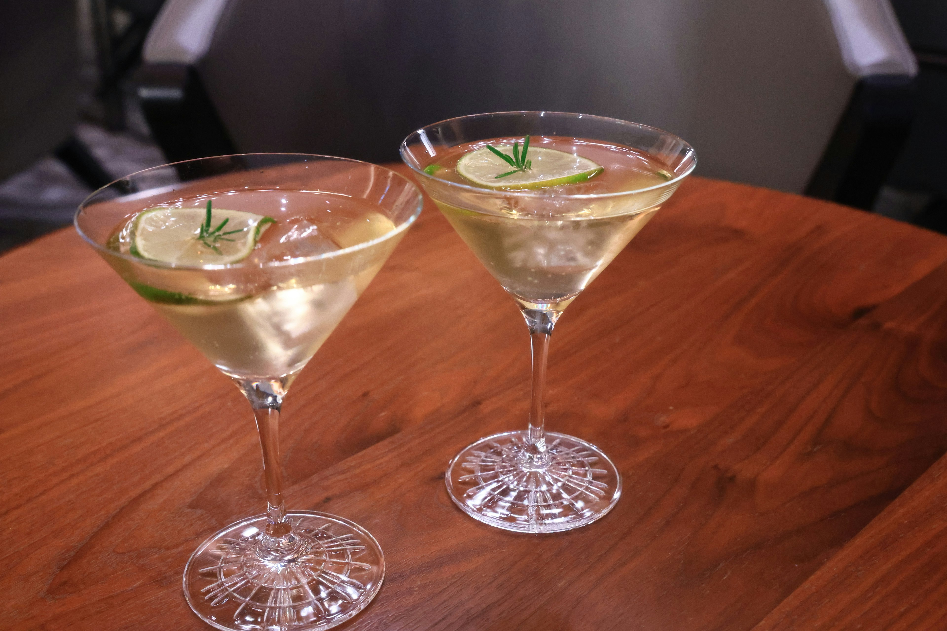 Two cocktail glasses with lime slices floating on top