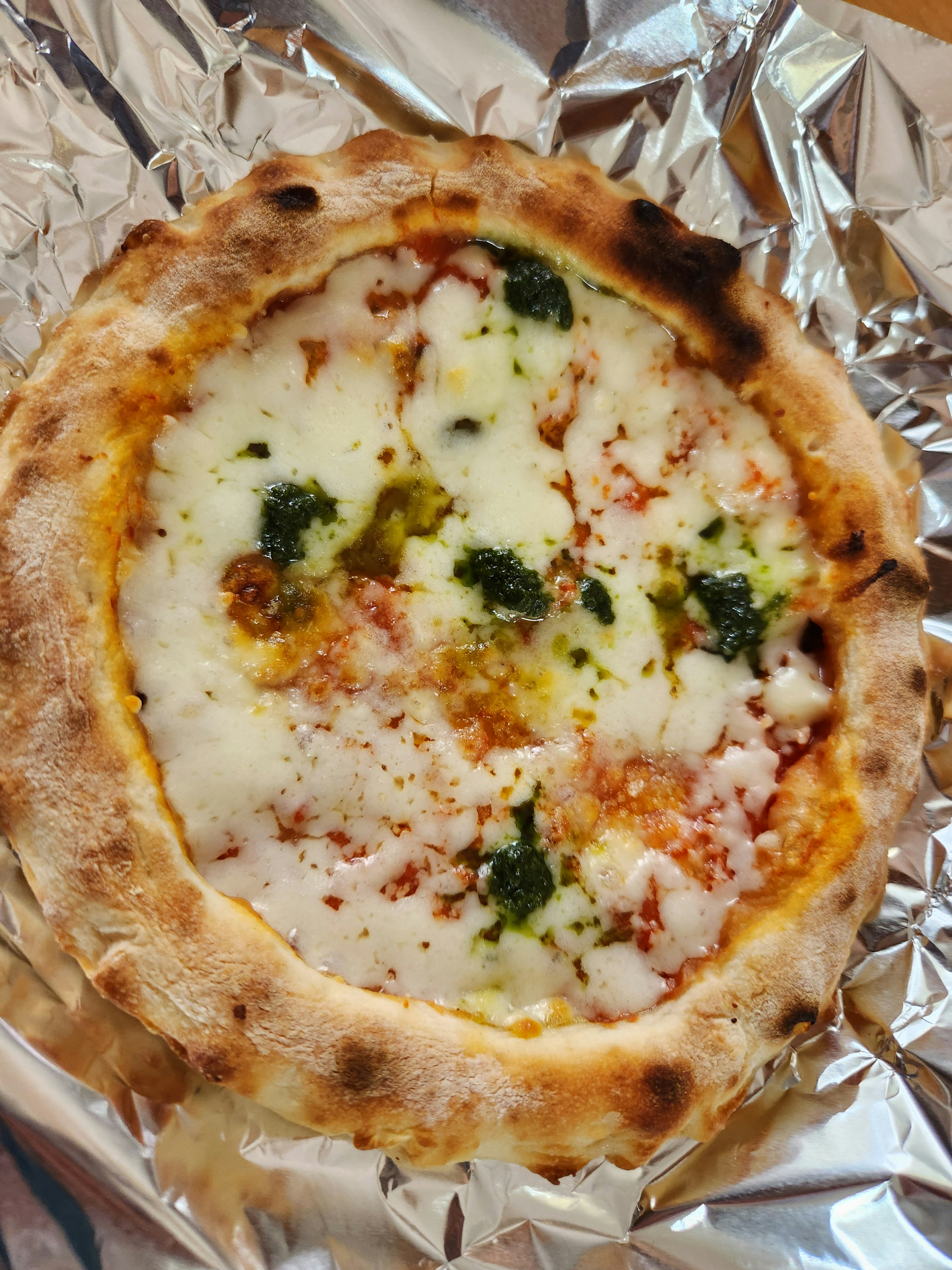 Pizza Margherita mới nướng với húng quế và phô mai mozzarella