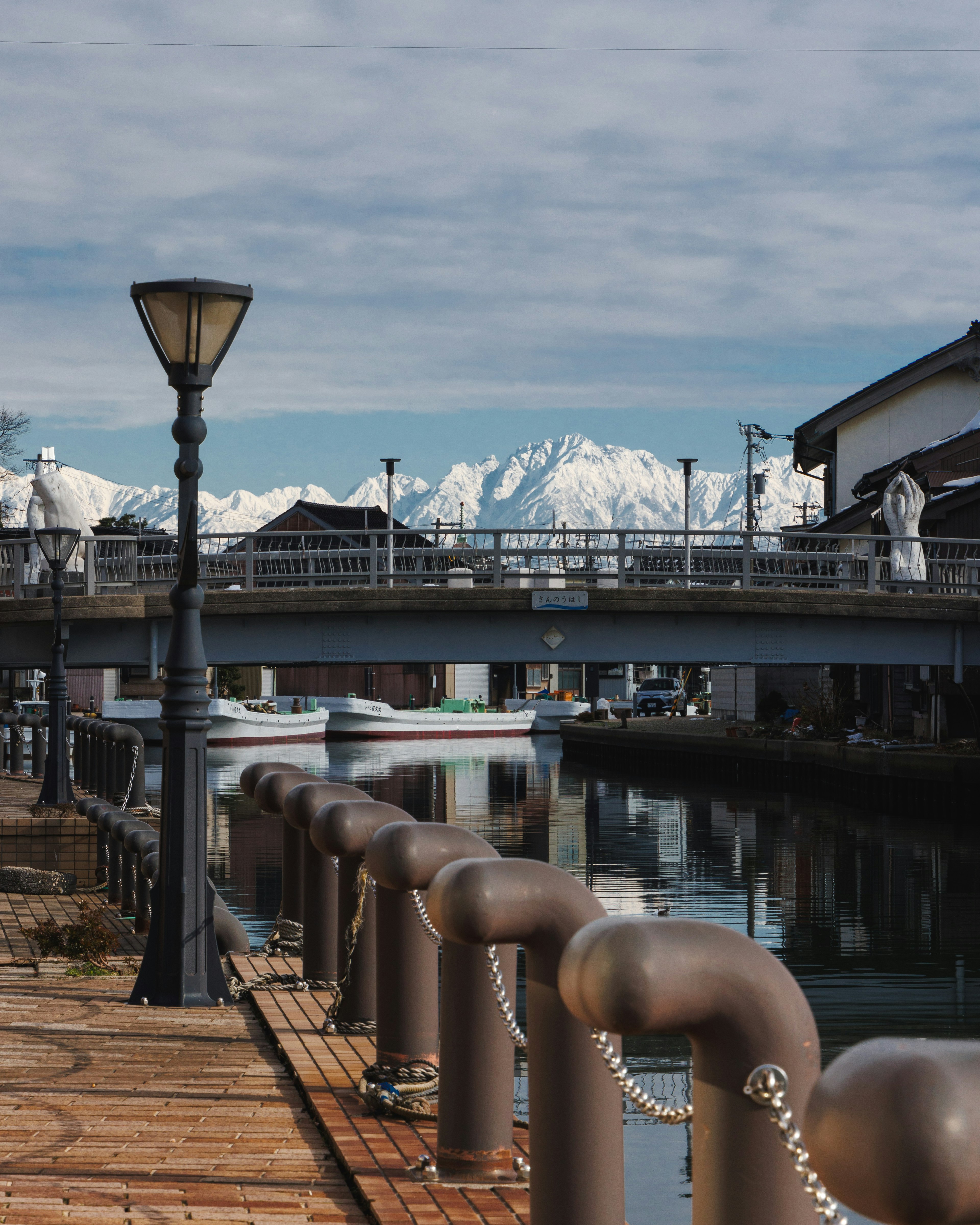 Vista escénica de un puerto con un puente y montañas nevadas