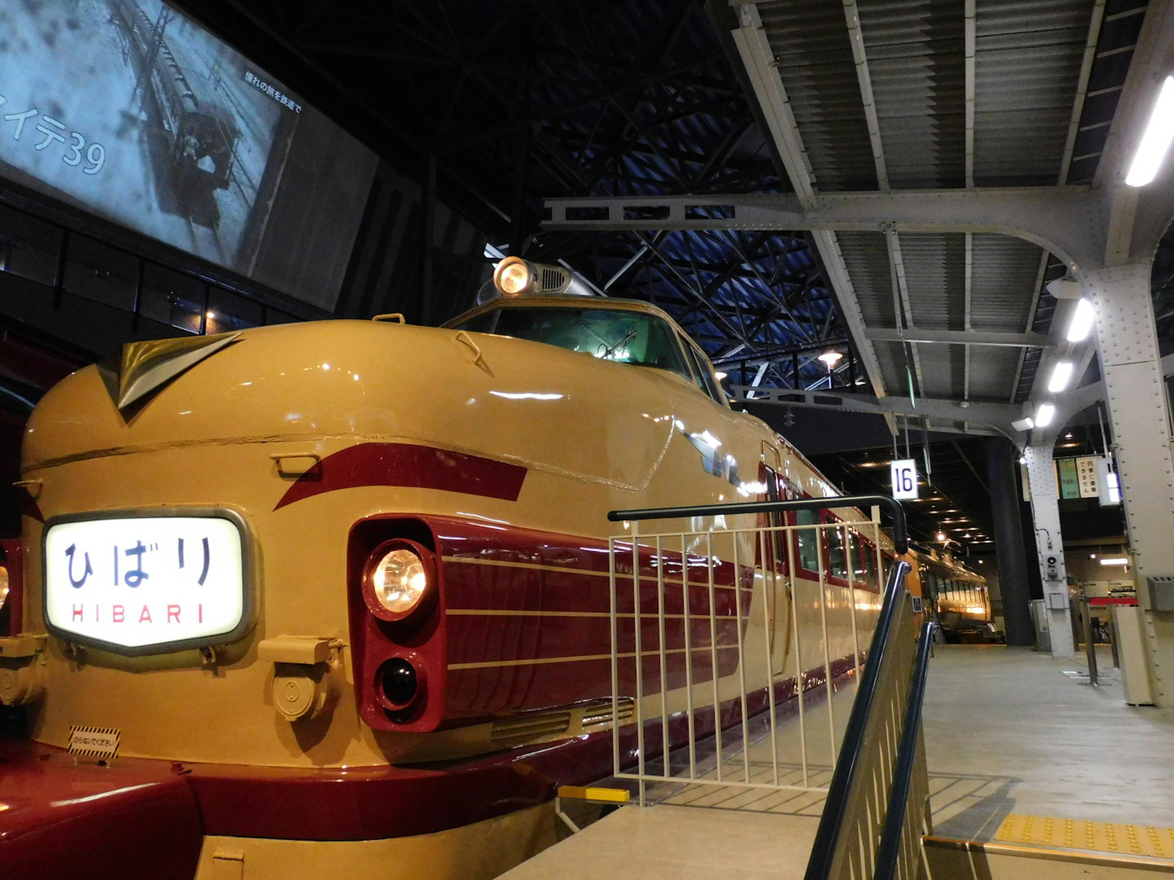 A Shinkansen train parked at a station showcasing its side view