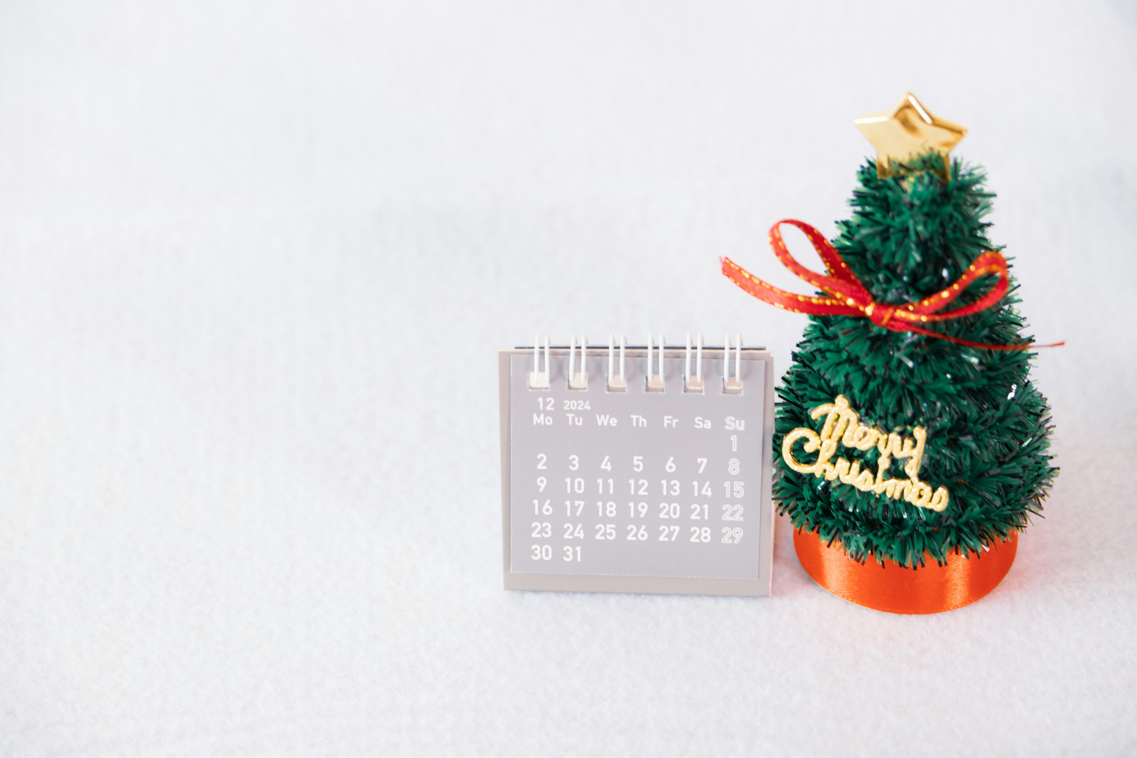 Imagen de un pequeño árbol de Navidad y un calendario