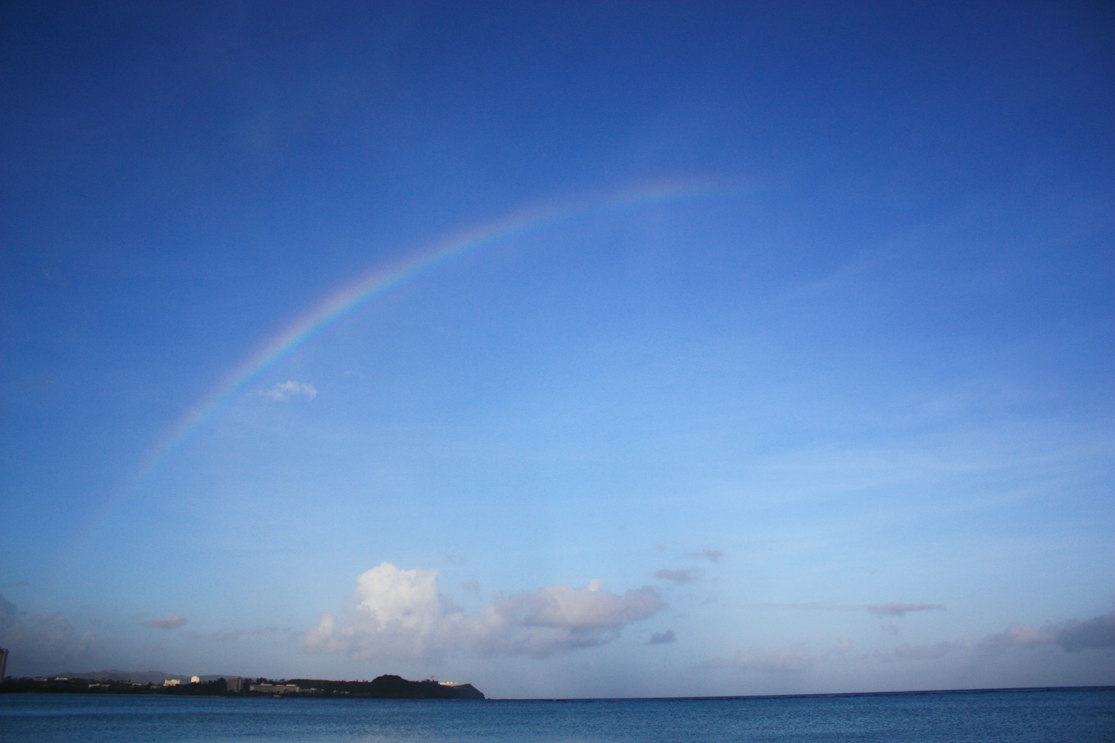 青空にかかる虹と海の風景