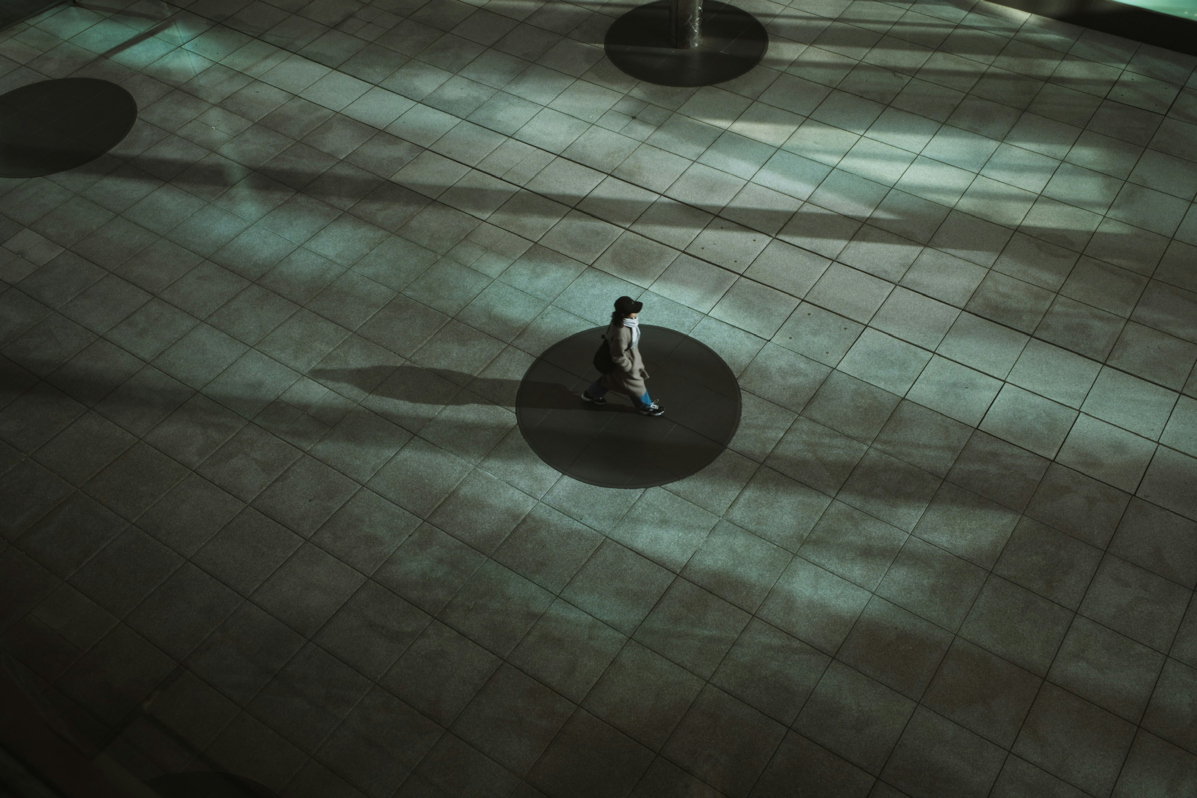 Silhouette of a person walking on a floor with shadows