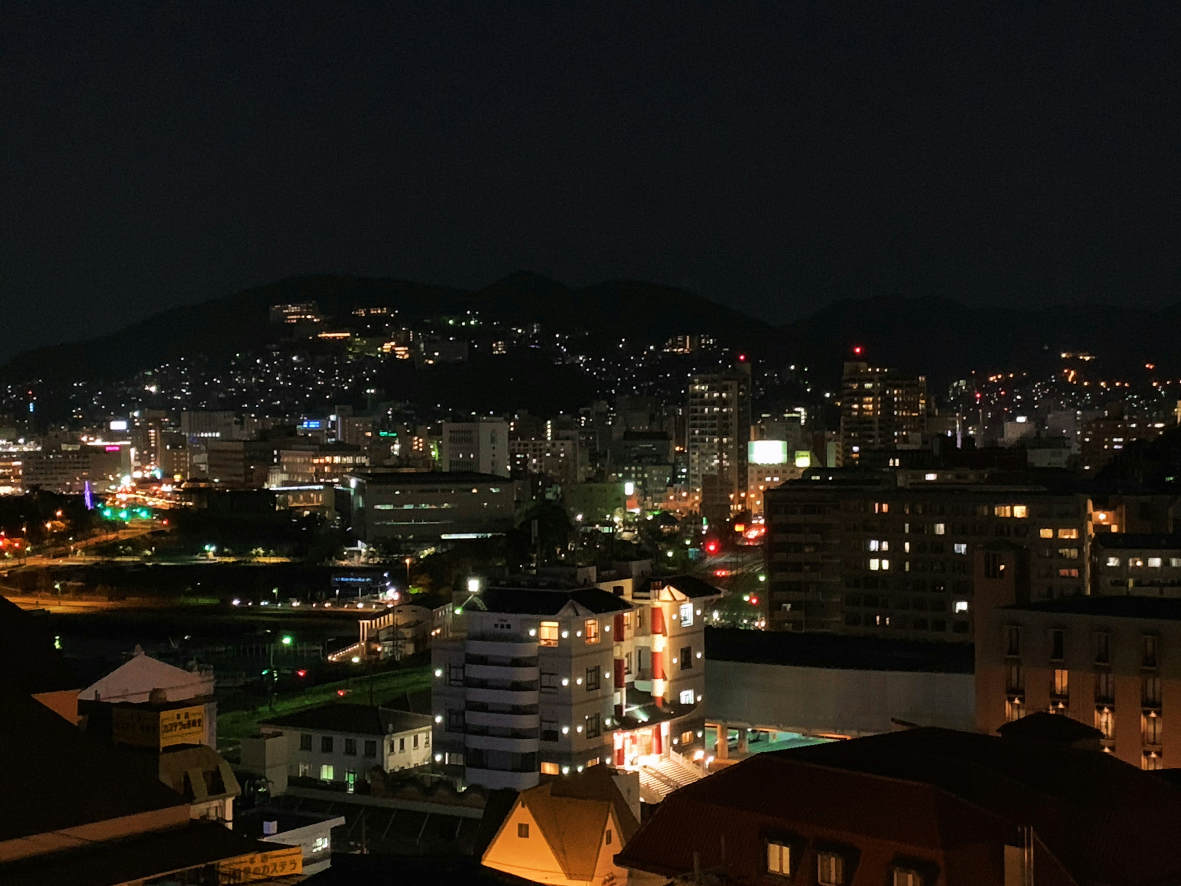 Paisaje urbano nocturno con edificios iluminados y luces vibrantes