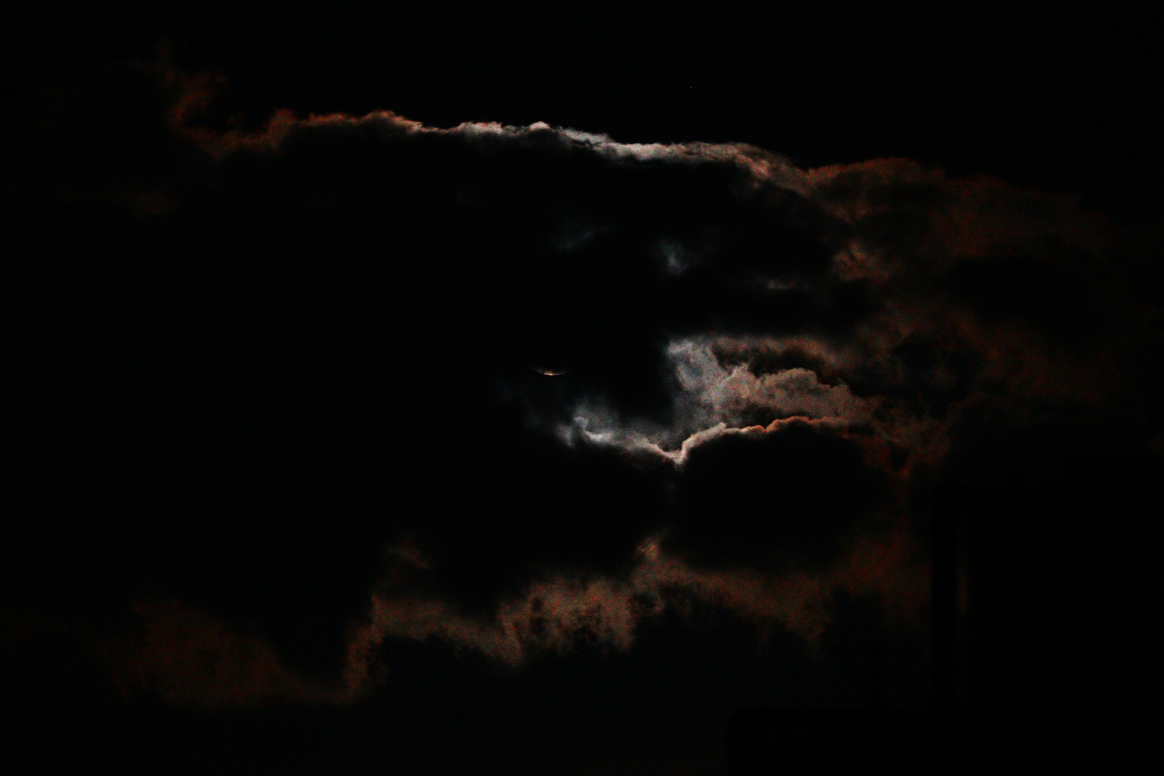 Langit malam dengan sinar bulan menembus awan gelap