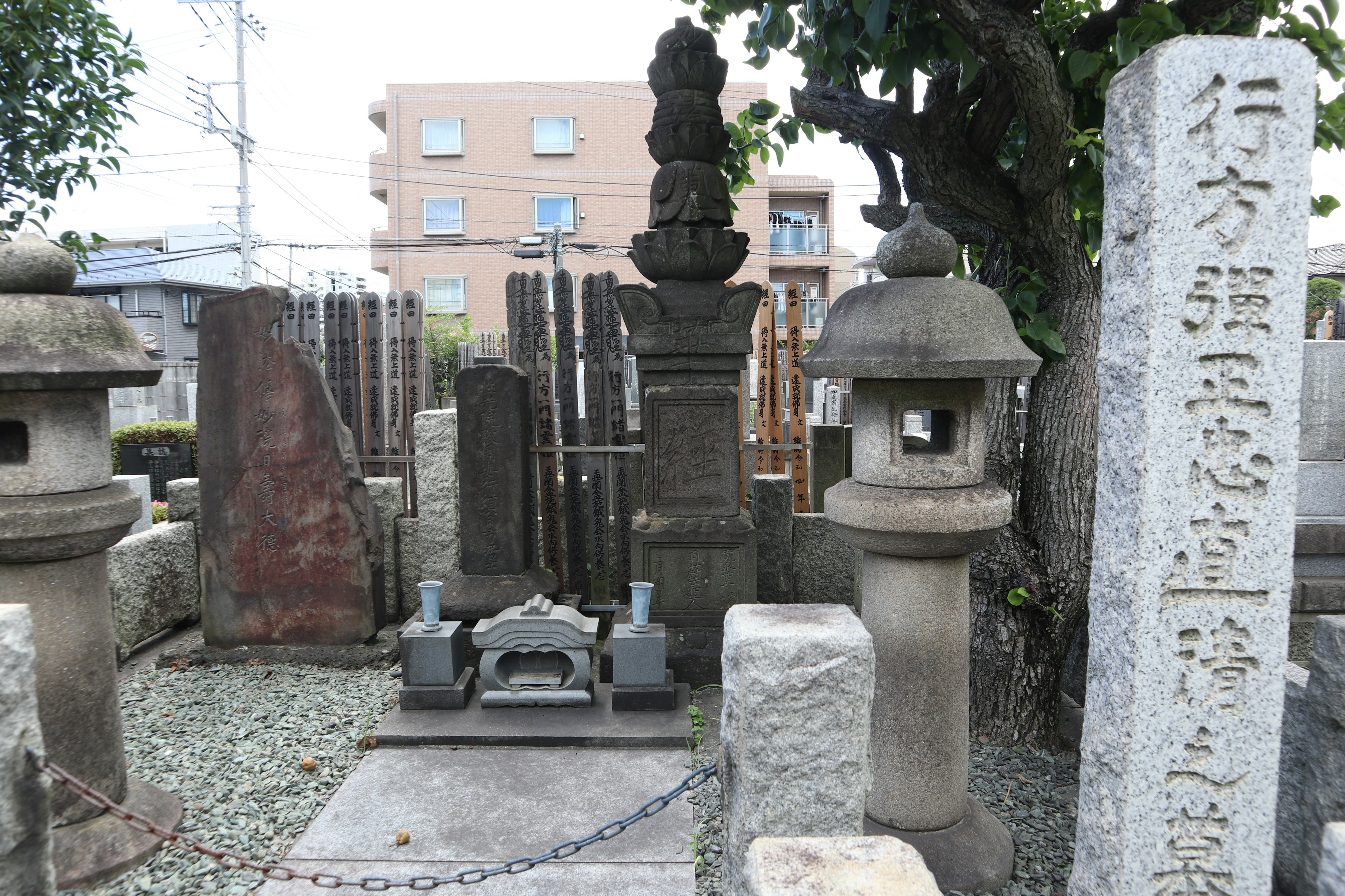 A serene cemetery scene featuring stone lanterns and grave markers