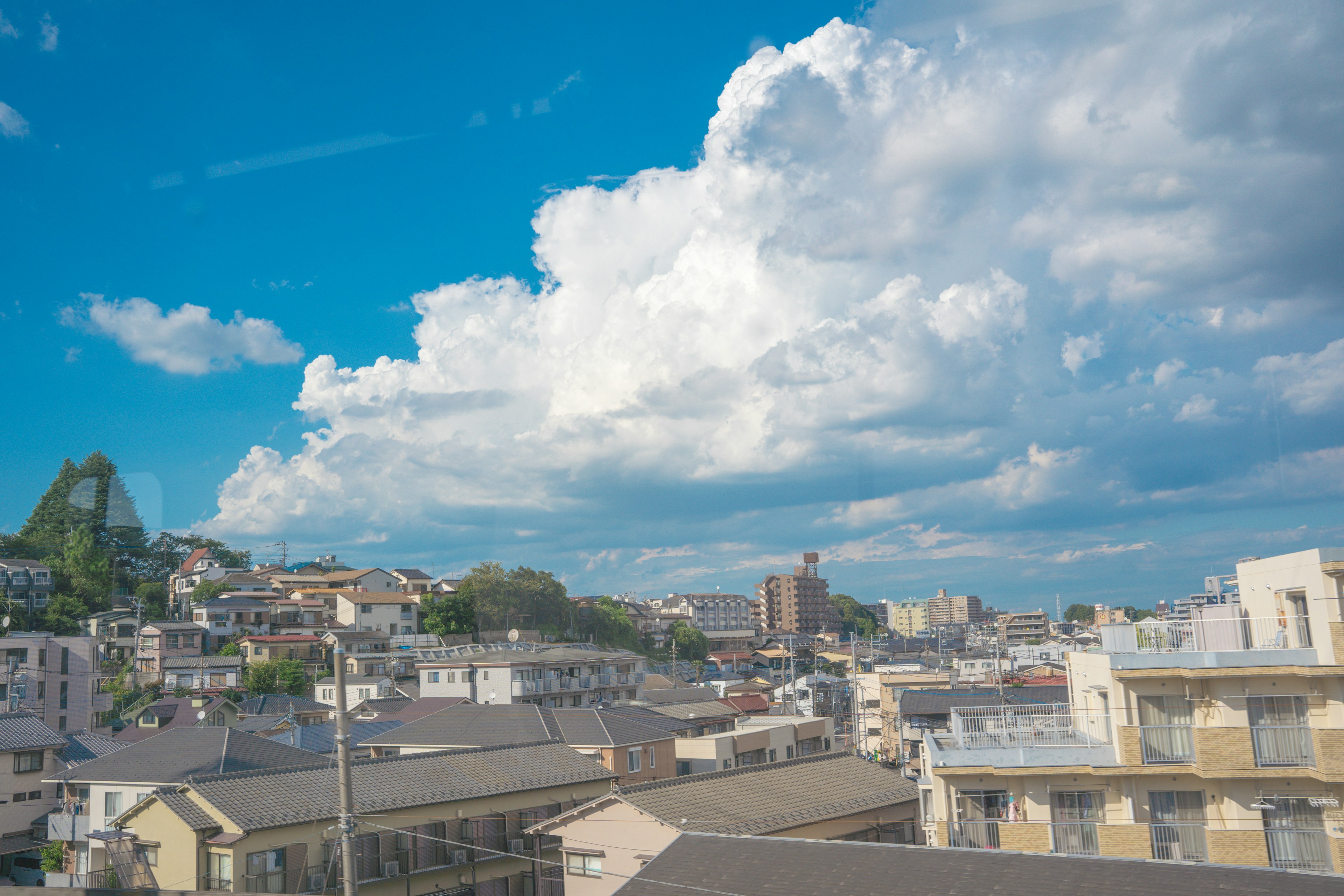 青空と白い雲に囲まれた都市の風景