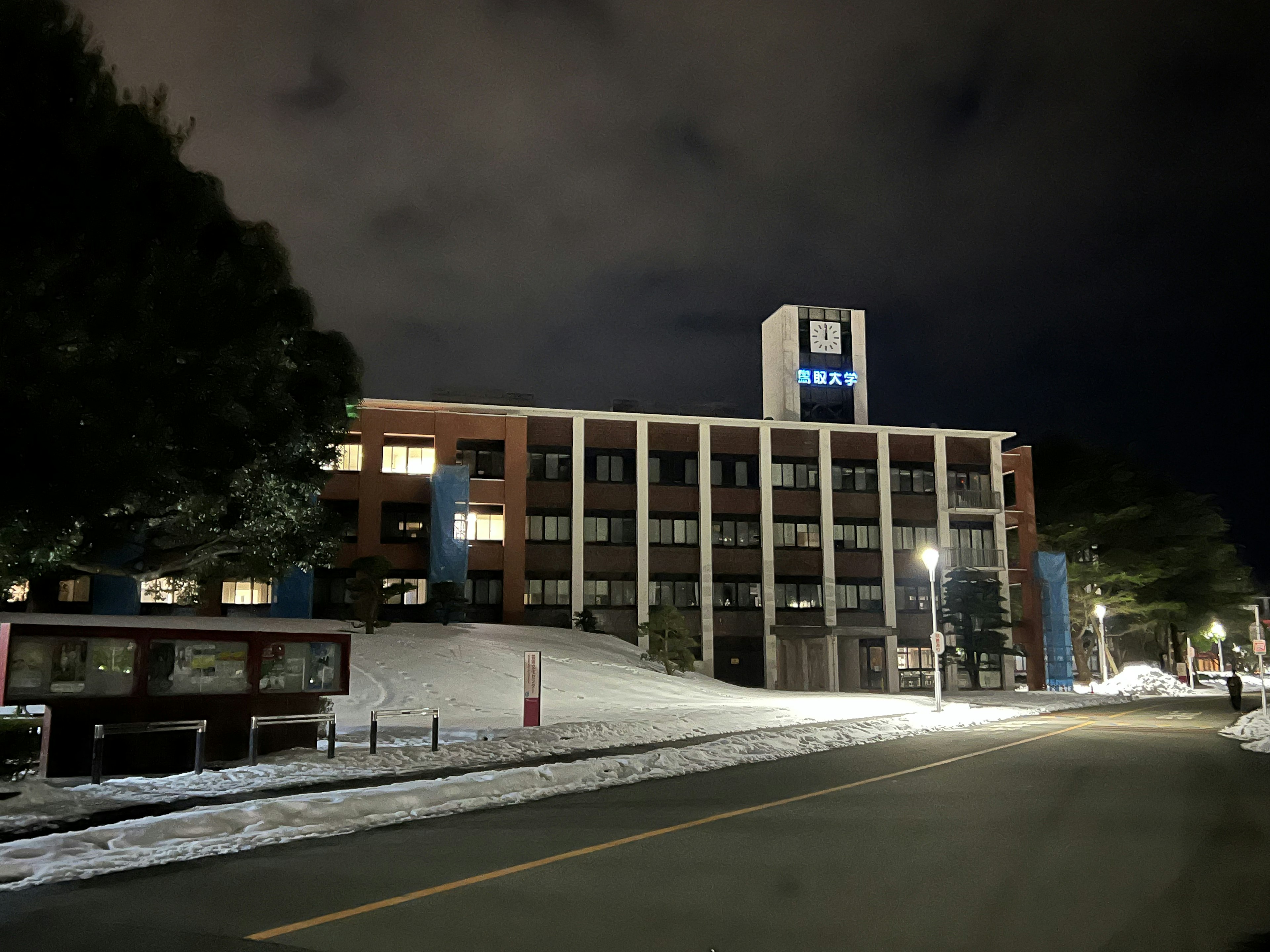 Vue extérieure d'un bâtiment scolaire la nuit avec un sol recouvert de neige