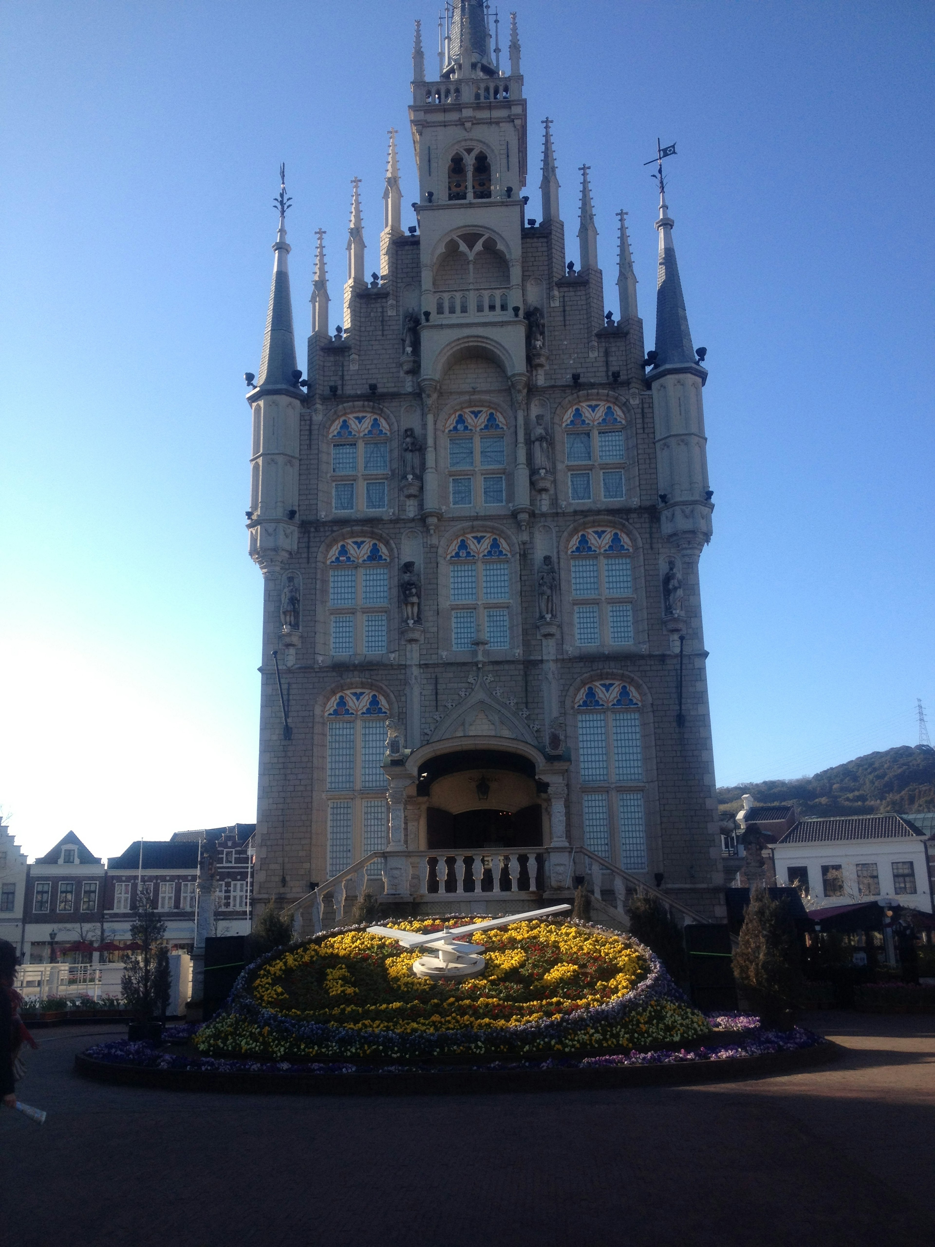 Una hermosa torre de castillo con un jardín de flores delante