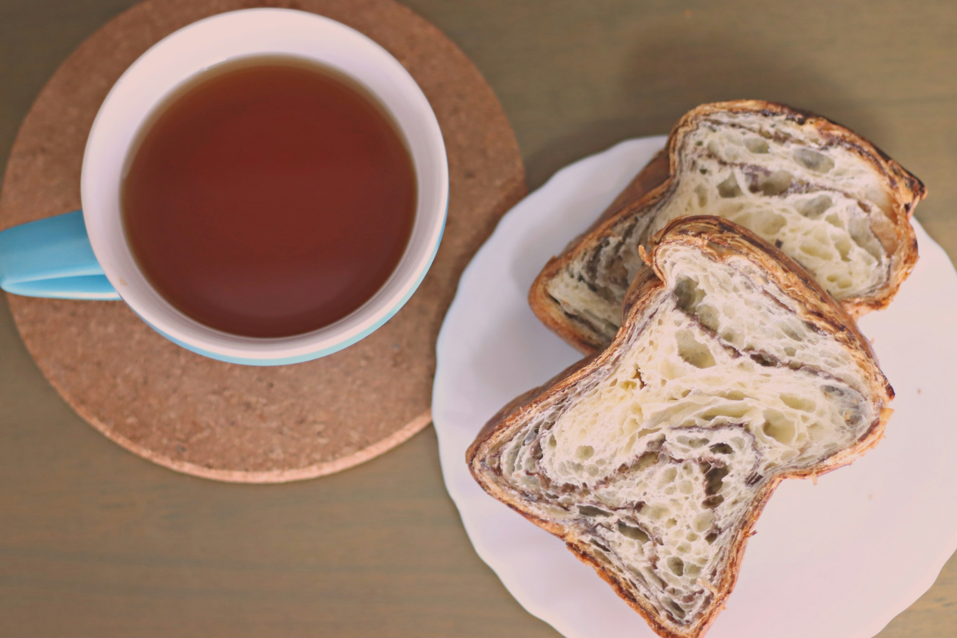 Eine Tasse Tee und Scheiben von Marmorbrot auf einem weißen Teller