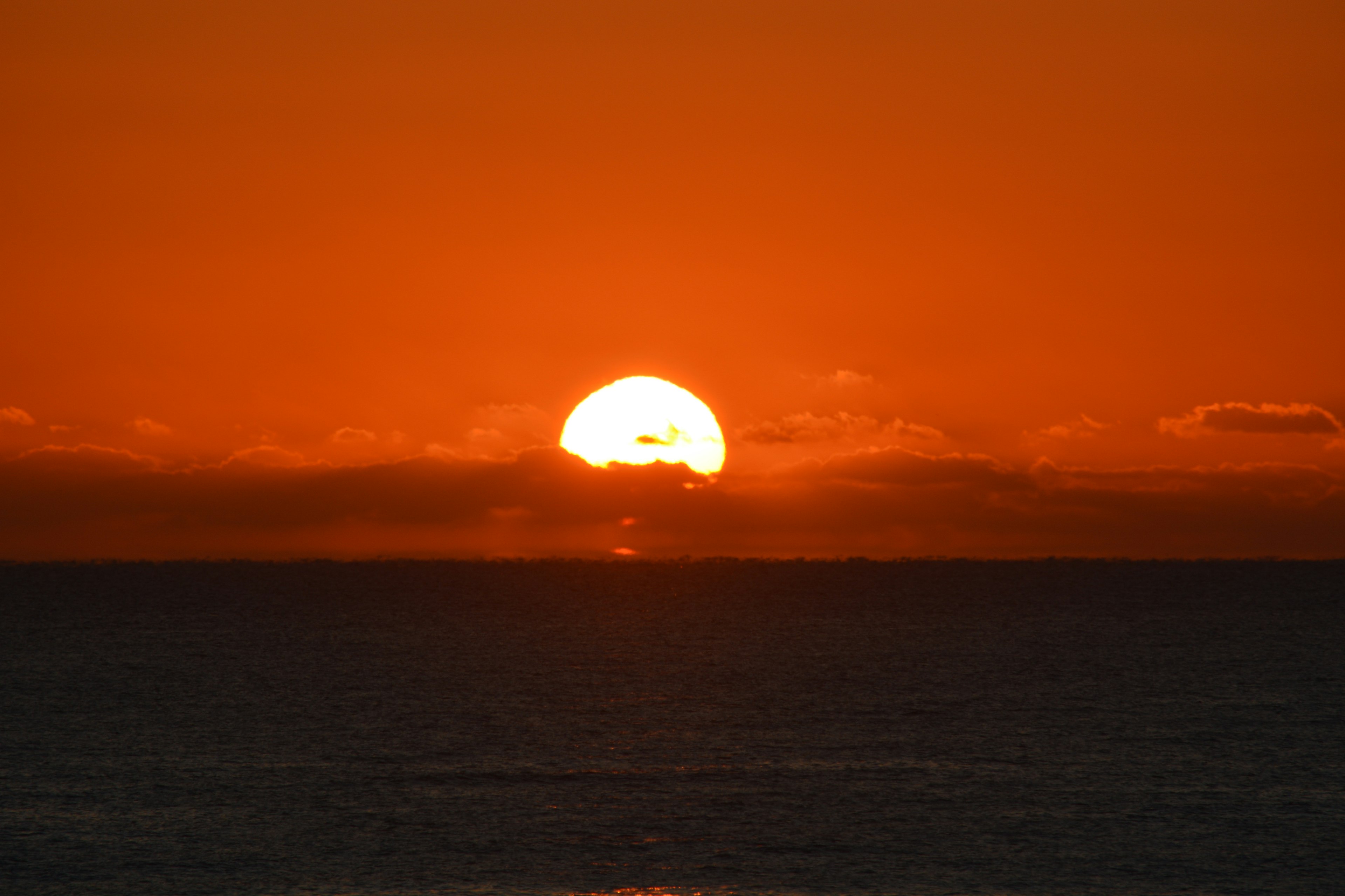 夕日が海の向こうに沈む美しいオレンジ色の空