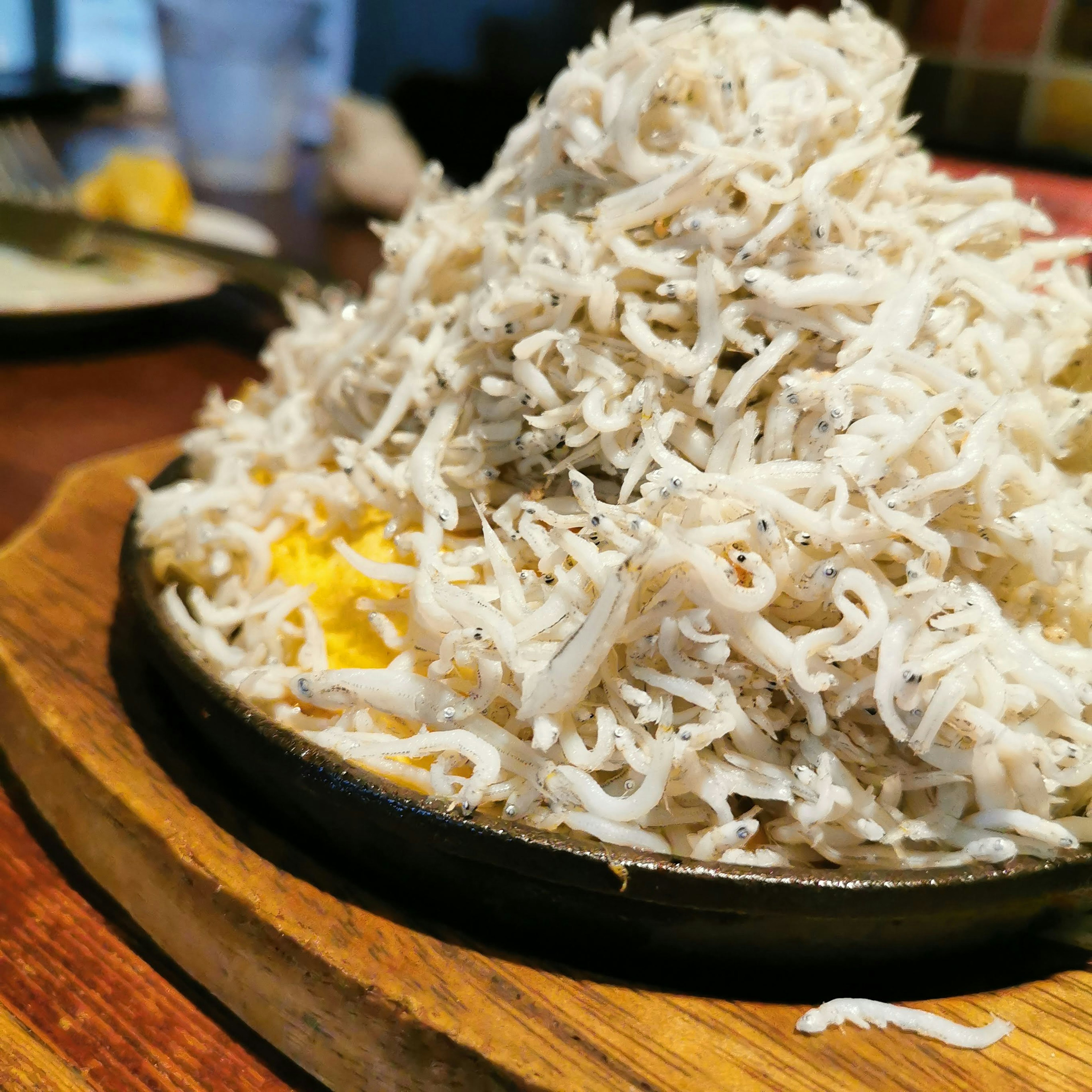 A mound of shirasu served on a hot iron plate