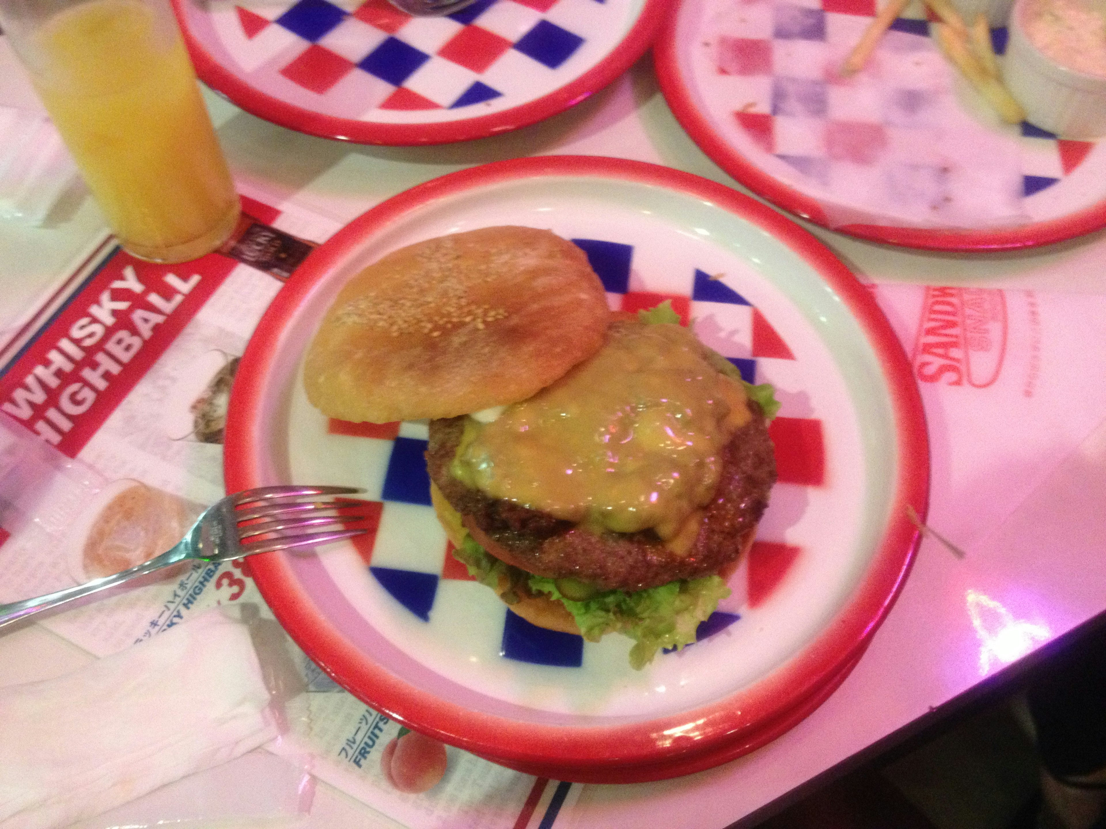 Une assiette à carreaux colorée avec un hamburger, de la laitue et de la sauce