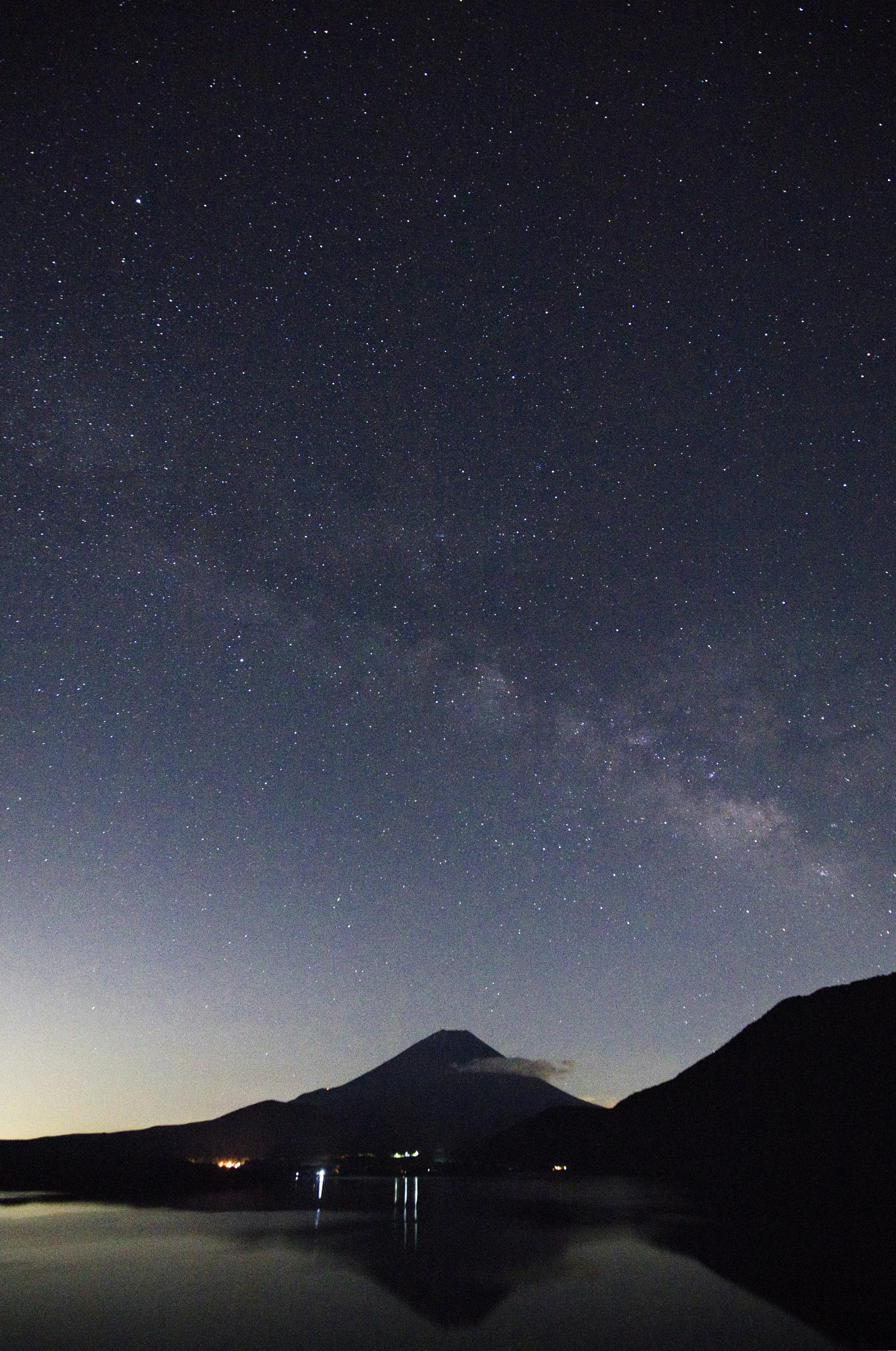 Langit berbintang yang memantul di danau tenang dengan Gunung Fuji