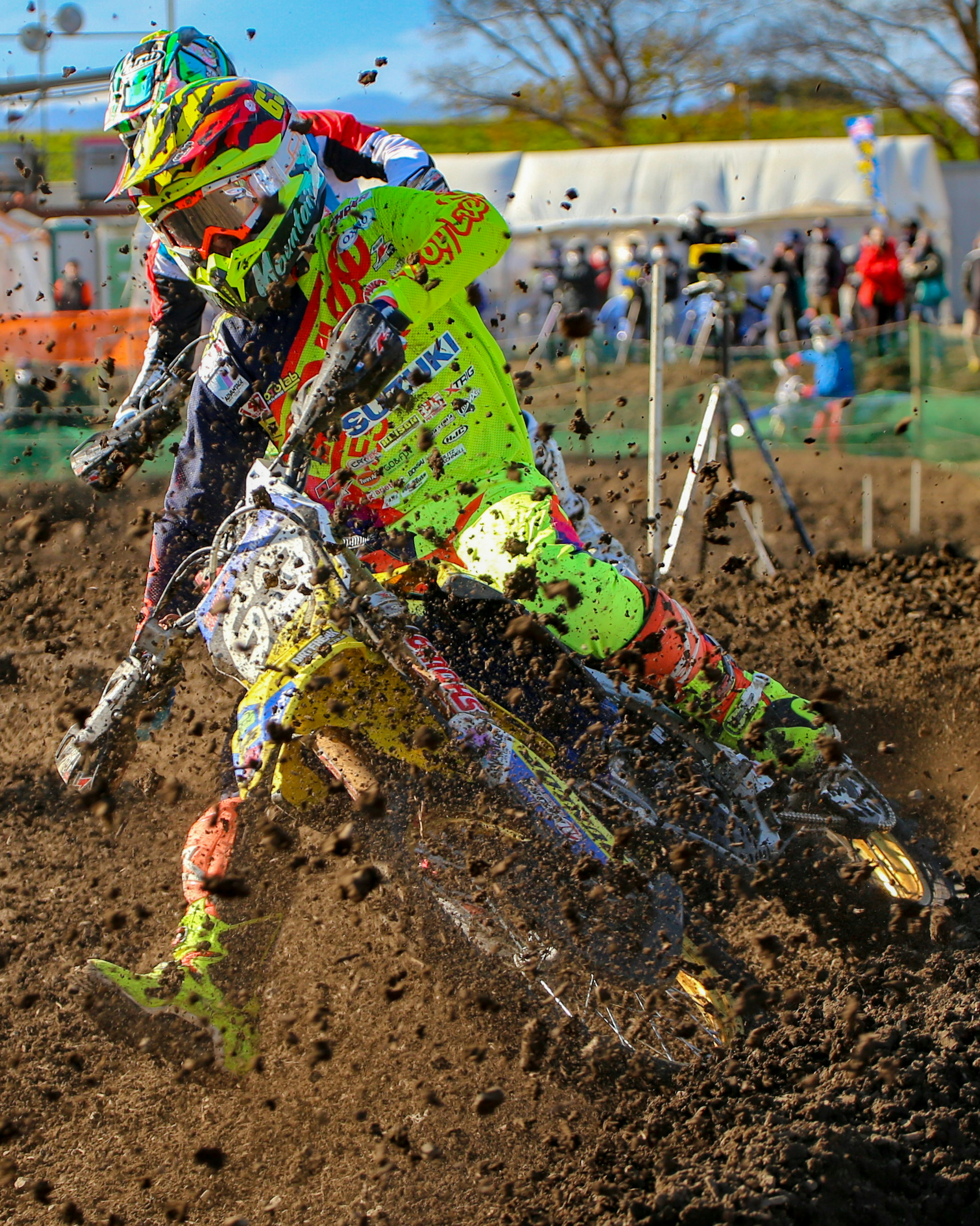 Pilote de motocross en tenue jaune vif courant dans la boue