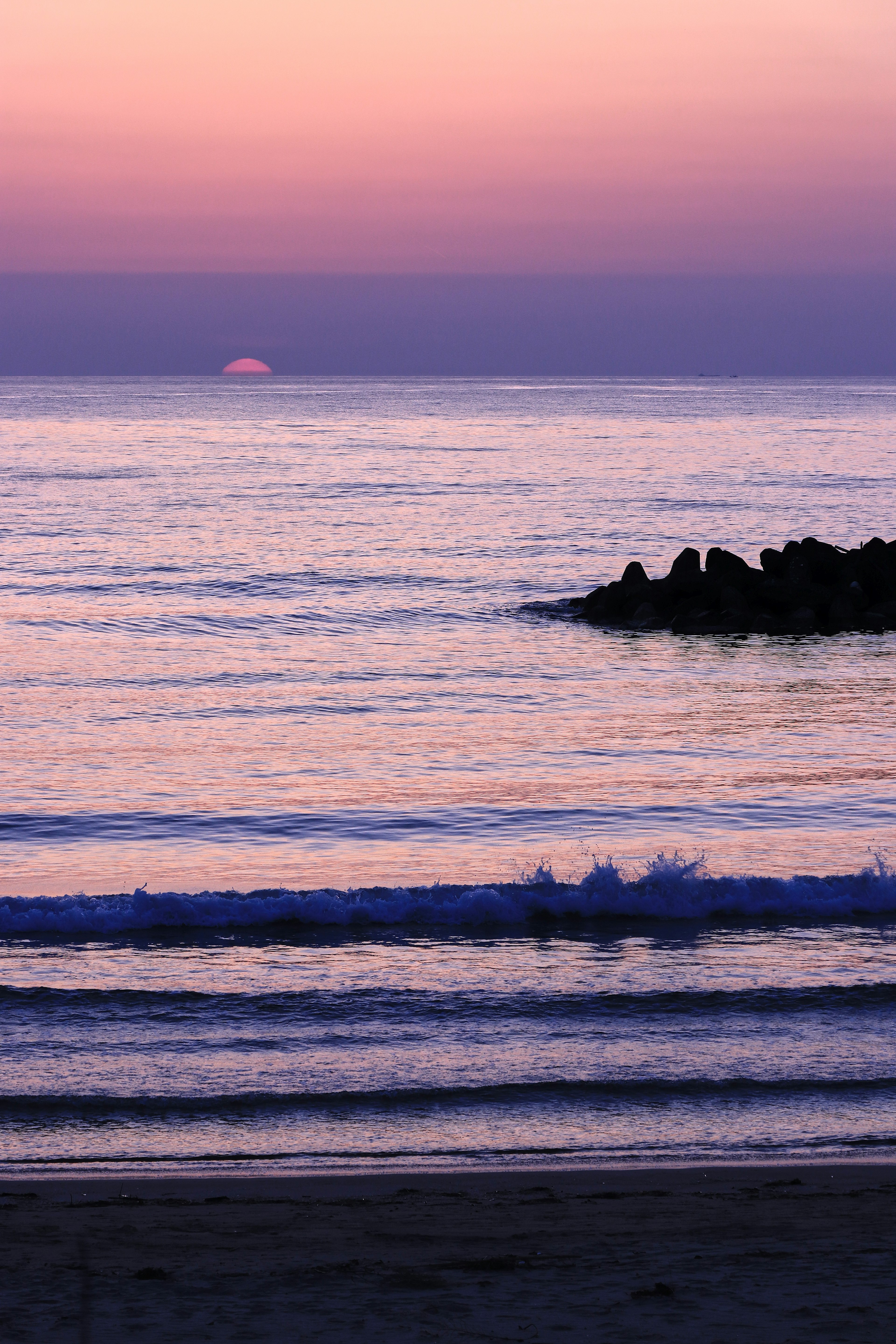 紫色の空と海が広がる夕暮れのビーチシーン