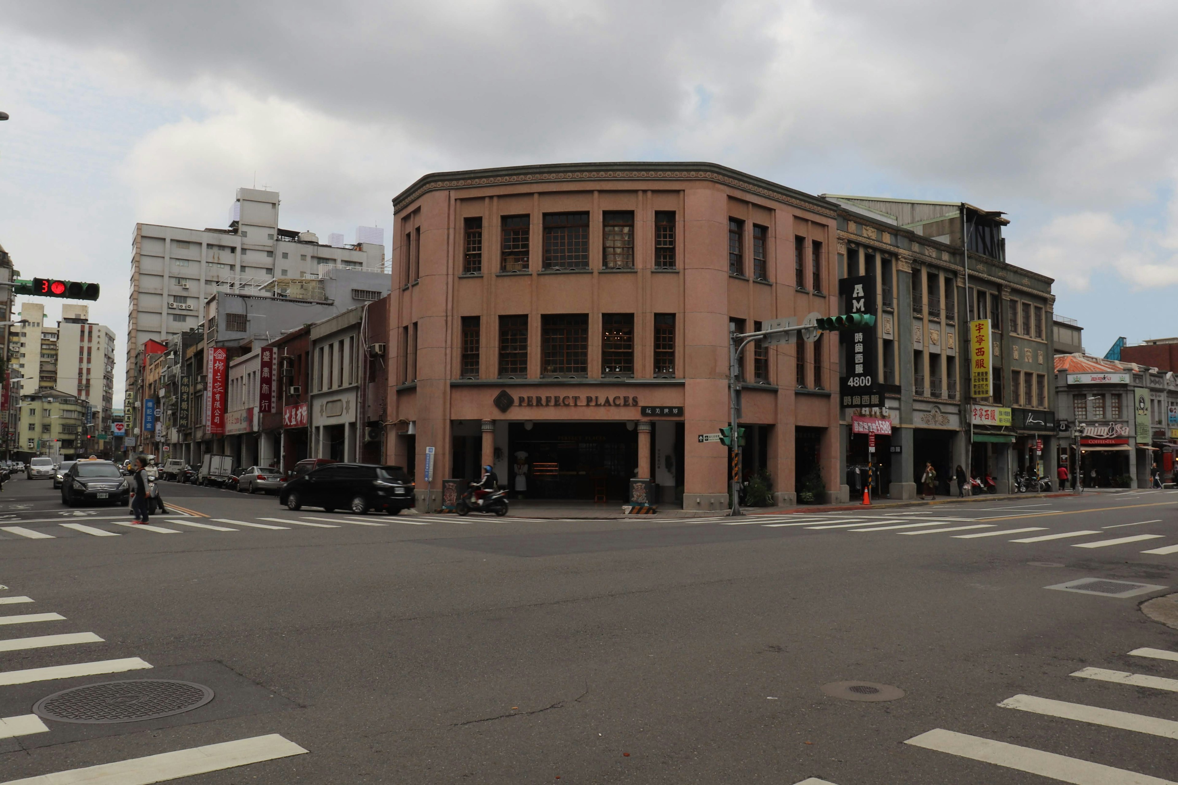 Historic building at the street corner with modern buildings in the background