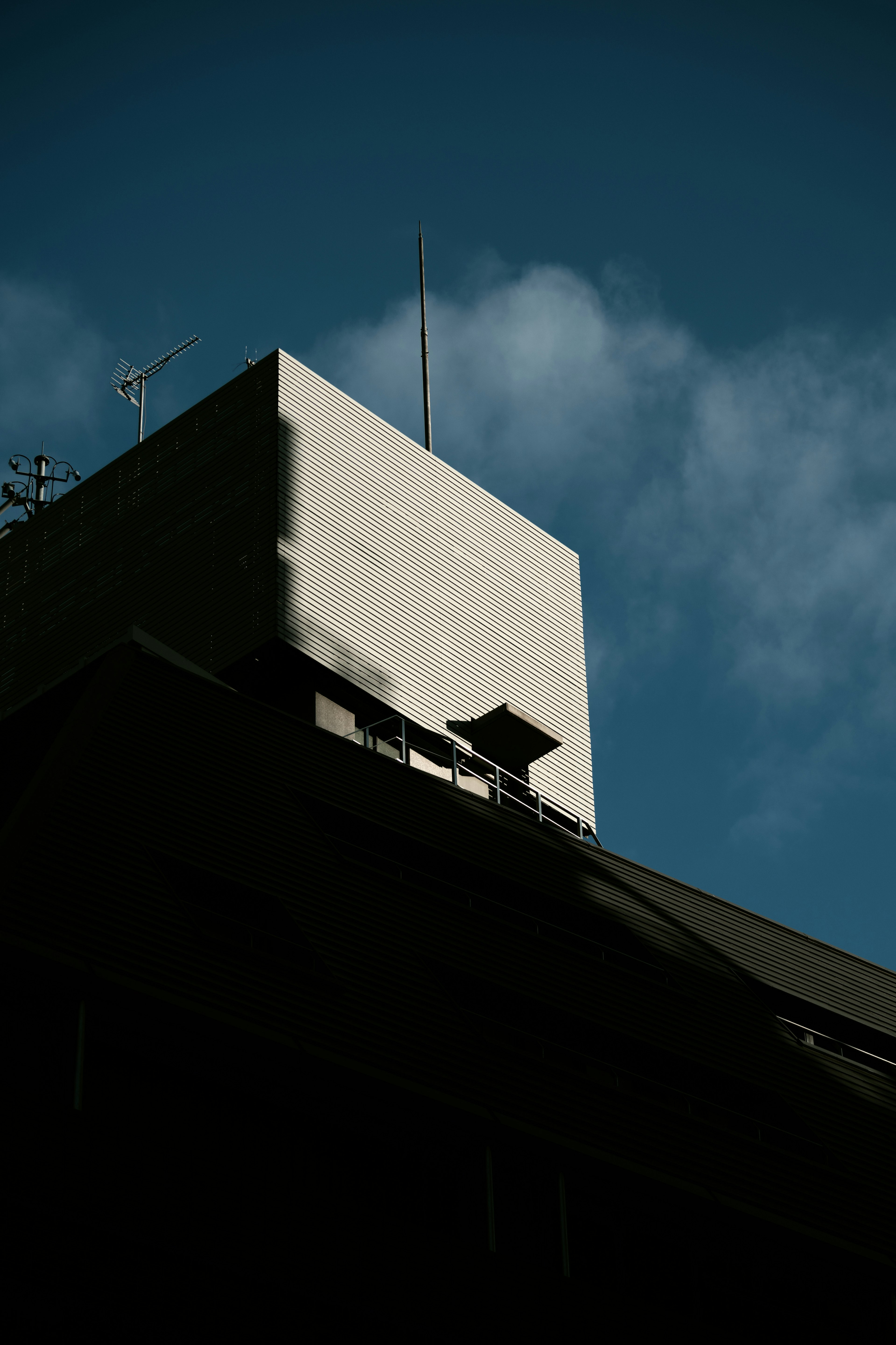 Contrast of a white wall on a tall building against a blue sky