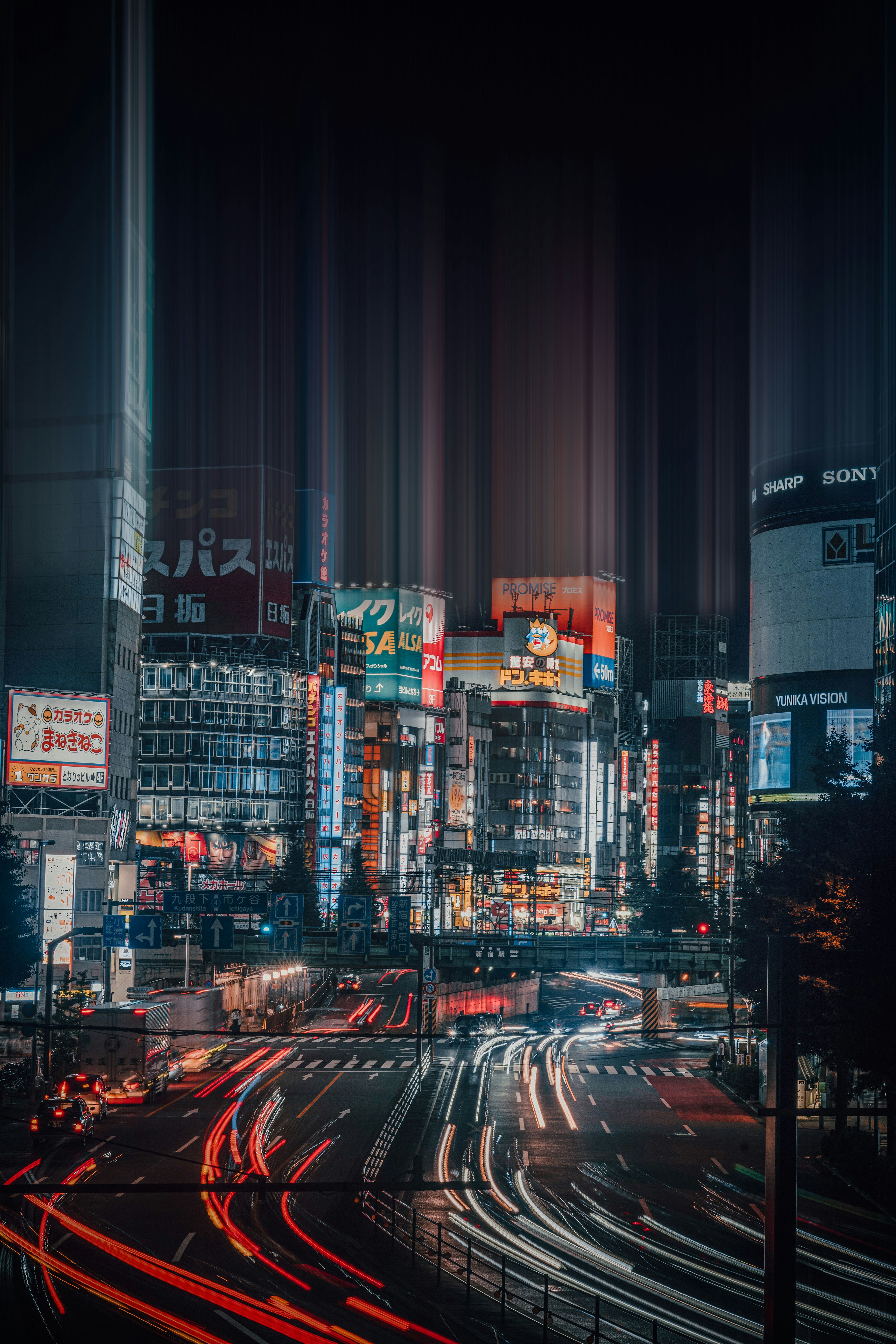 Vista nocturna del cruce de Shibuya en Tokio con colores vibrantes y estelas de luz