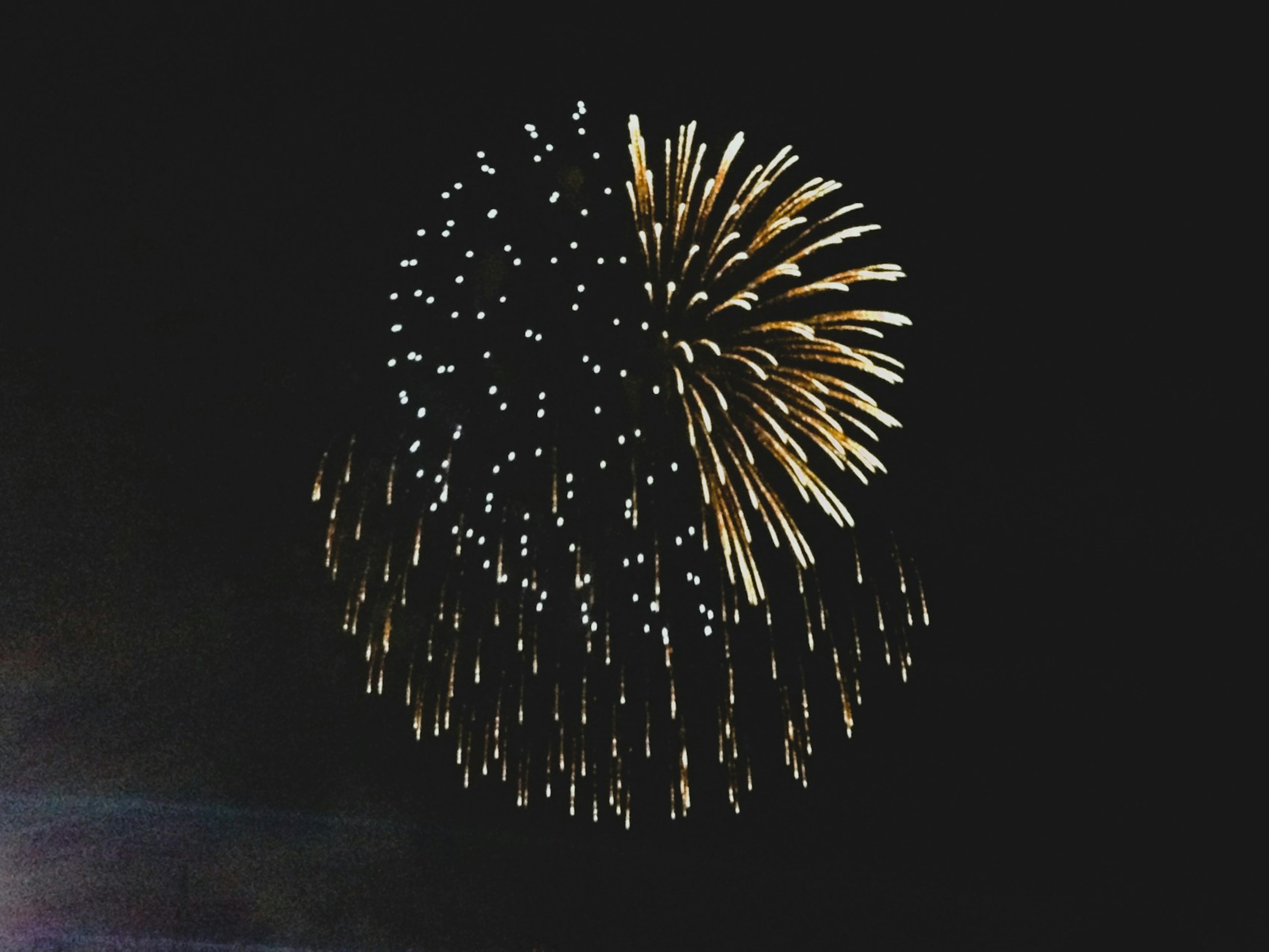 Golden fireworks bursting in the night sky