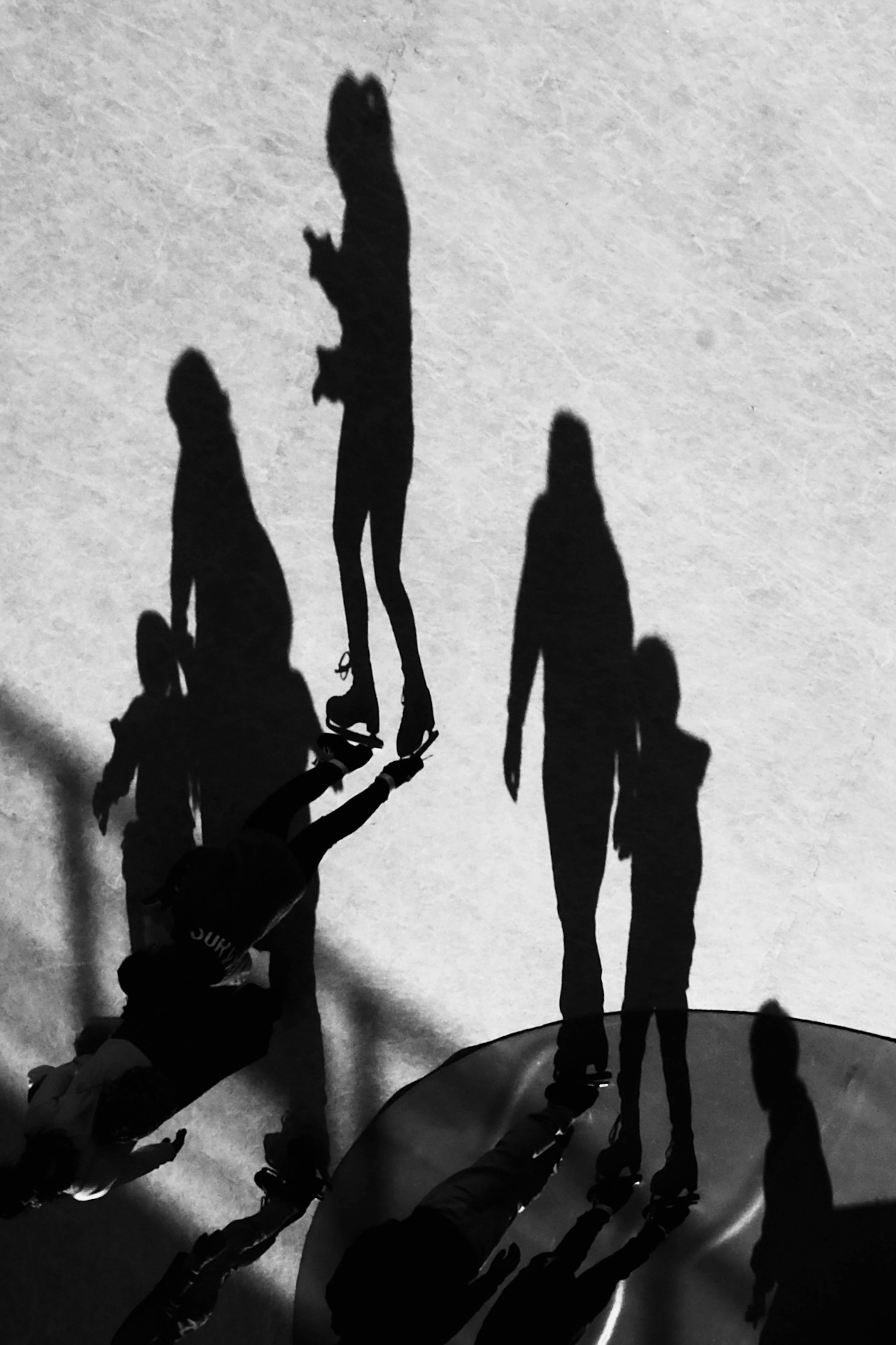 Foto en blanco y negro que muestra siluetas de personas caminando