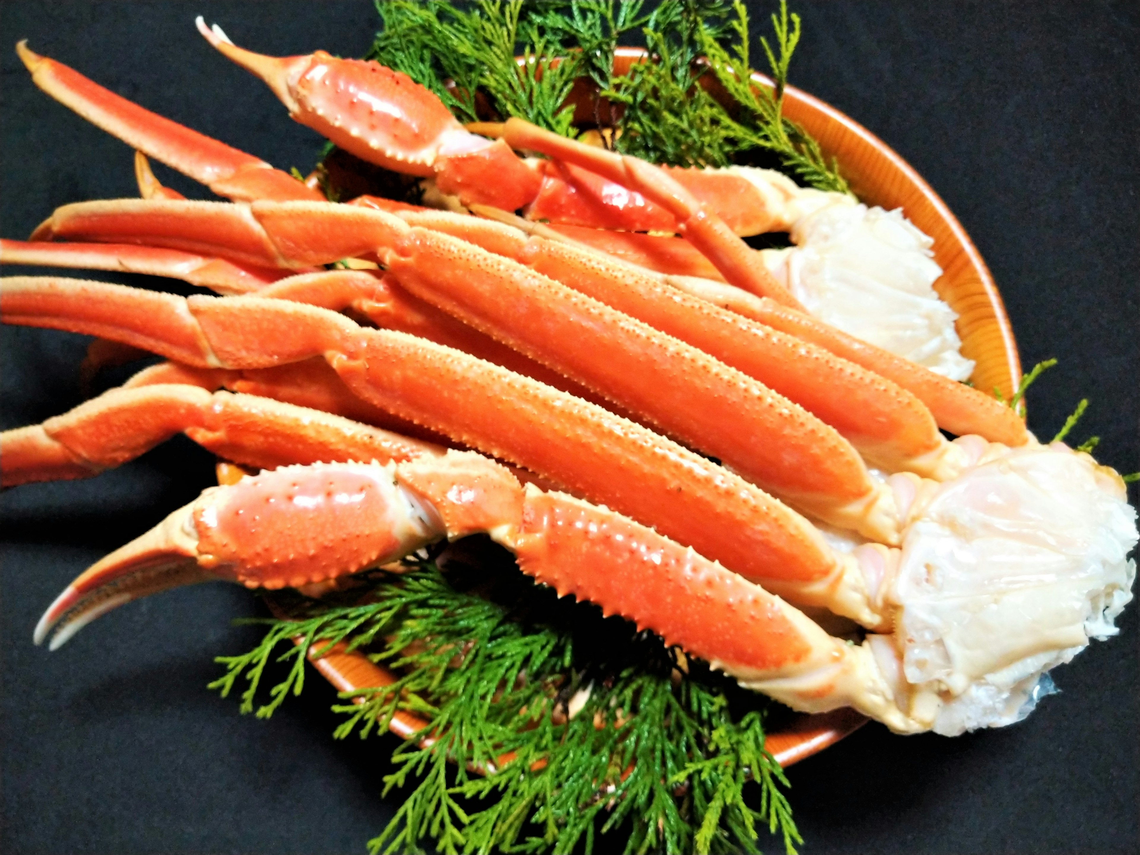 Pattes de crabe fraîches disposées sur une assiette avec garniture verte