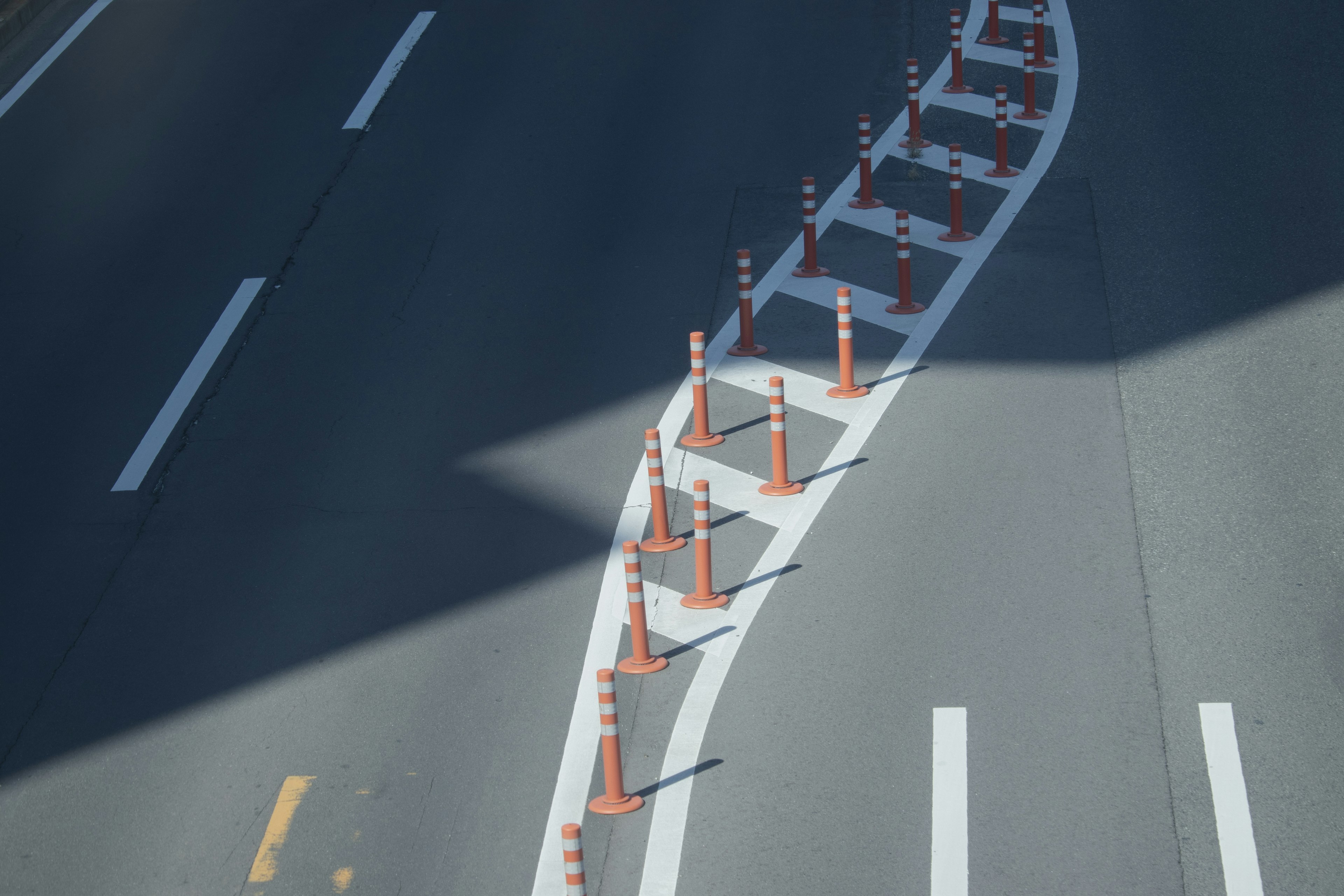 Orange traffic cones arranged along a curved road