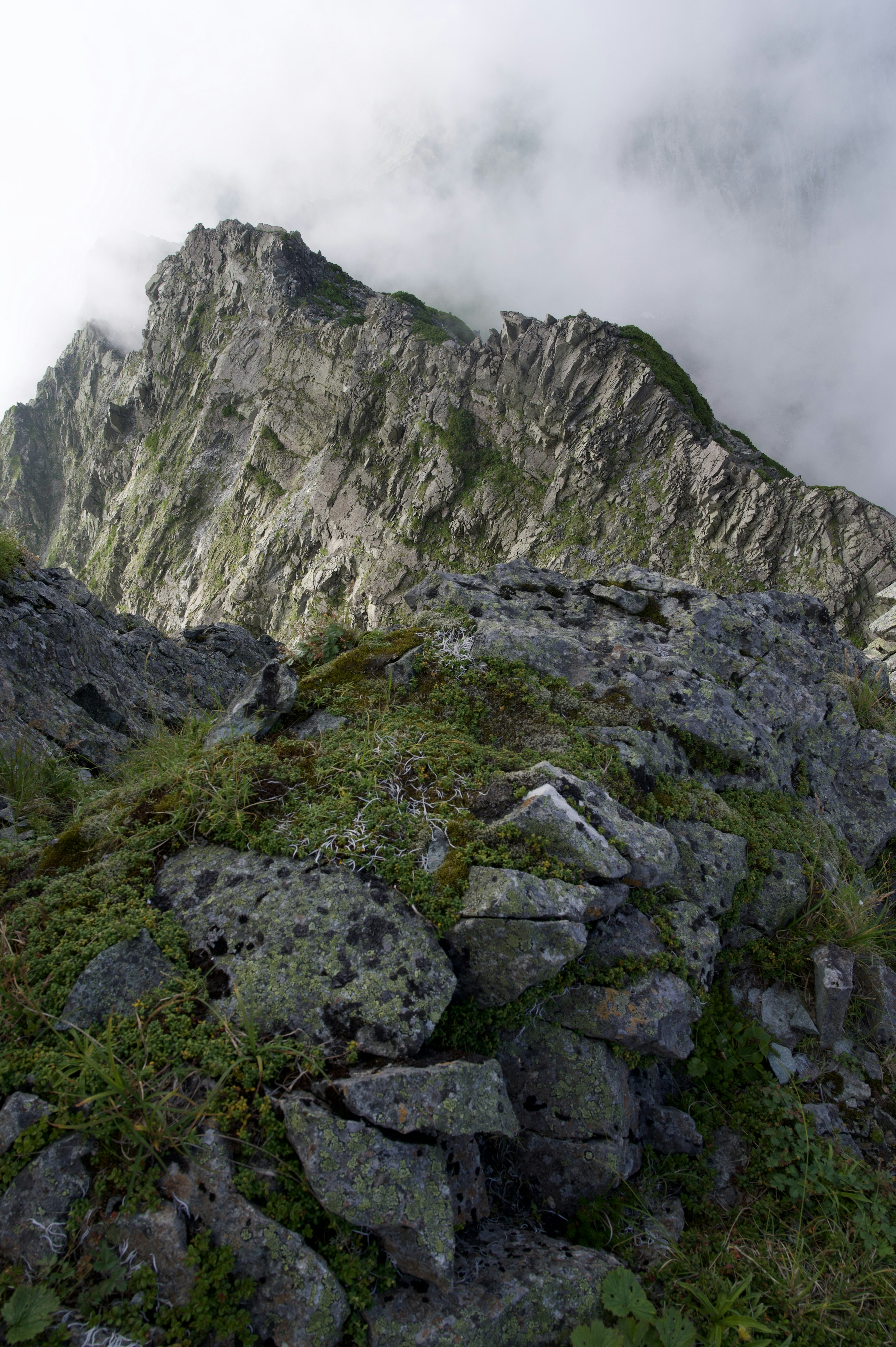 Rocky terrain near the mountain peak with clouds