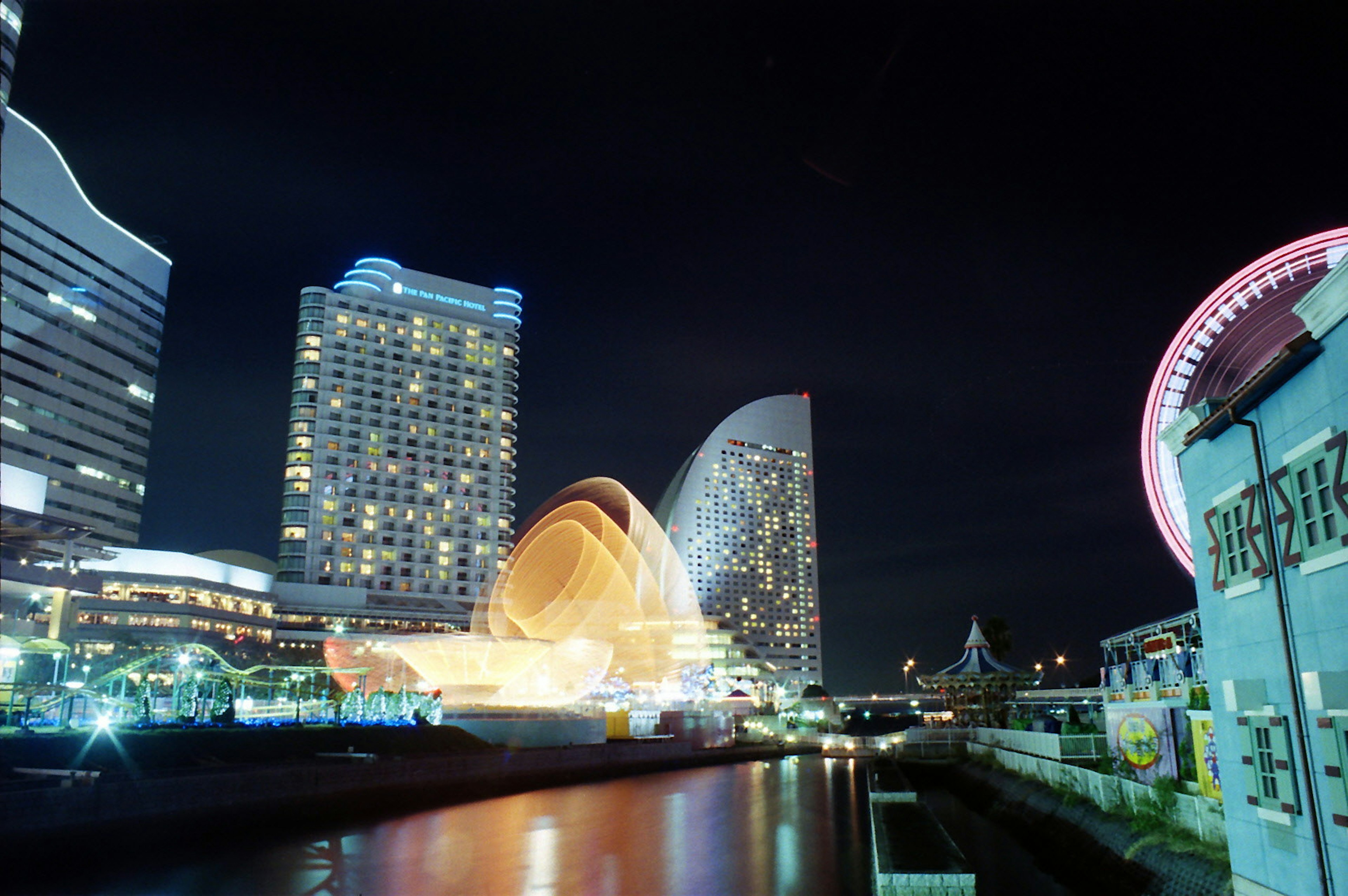 Nighttime view of Yokohama waterfront featuring skyscrapers and vibrant lights