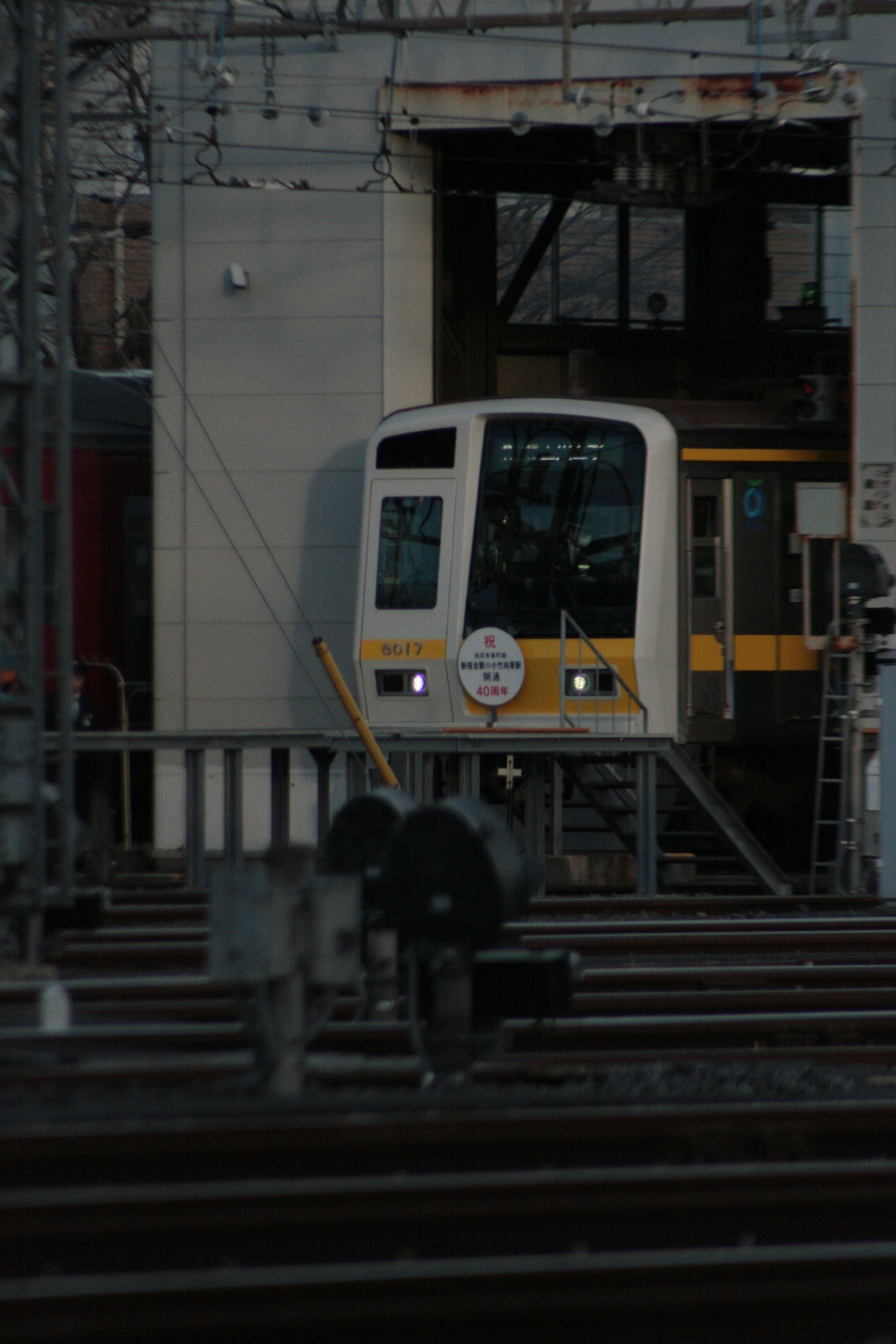 A train entering a station with lights on