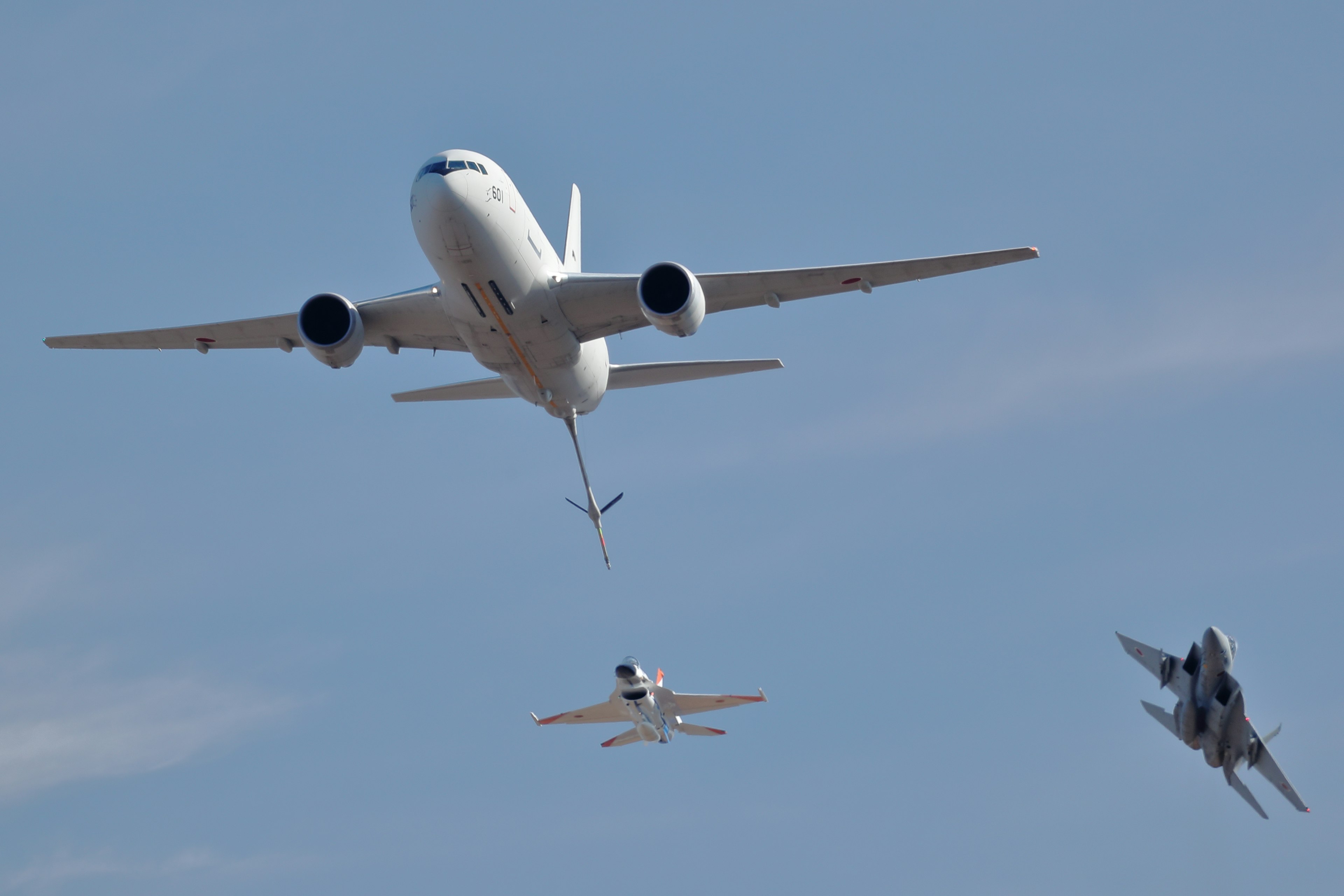 空を飛ぶ商業機と戦闘機の編隊飛行