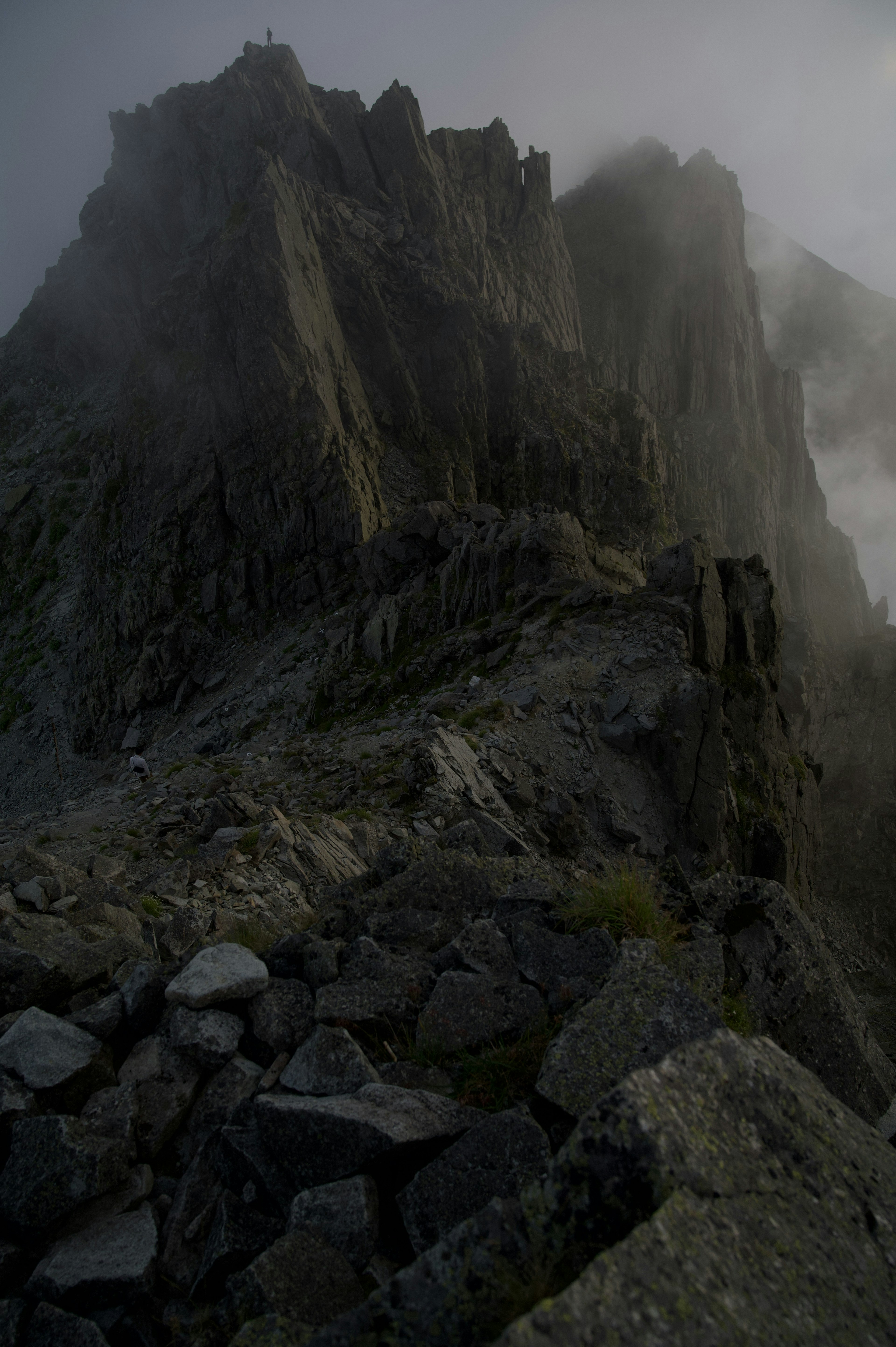 Eine zerklüftete Berglandschaft, die in Nebel gehüllt ist